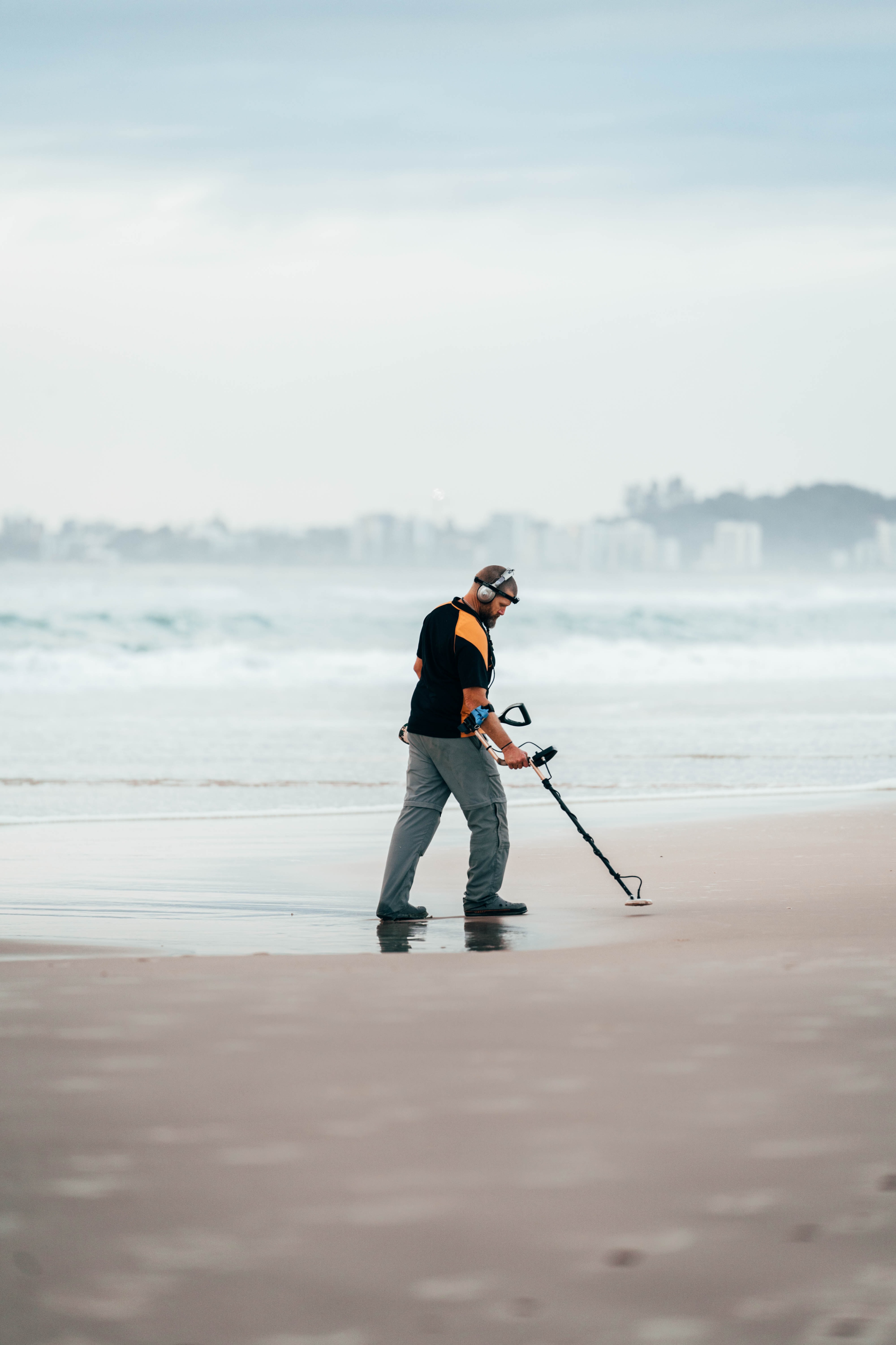 A man uses his metal detector on a beach | Photo: Unsplash/Carnaby Gilany