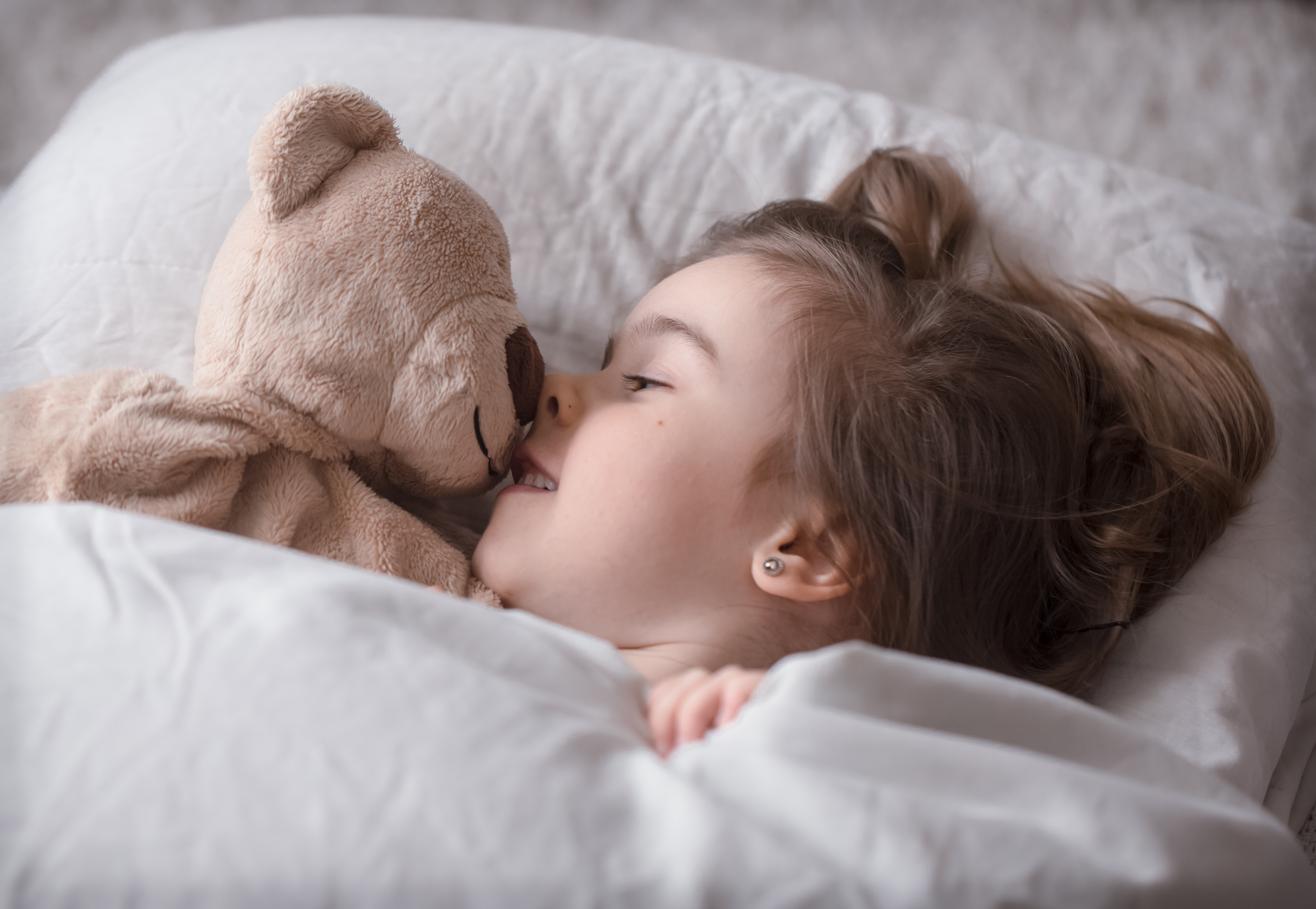 A smiling girl in her bed | Source: Freepik