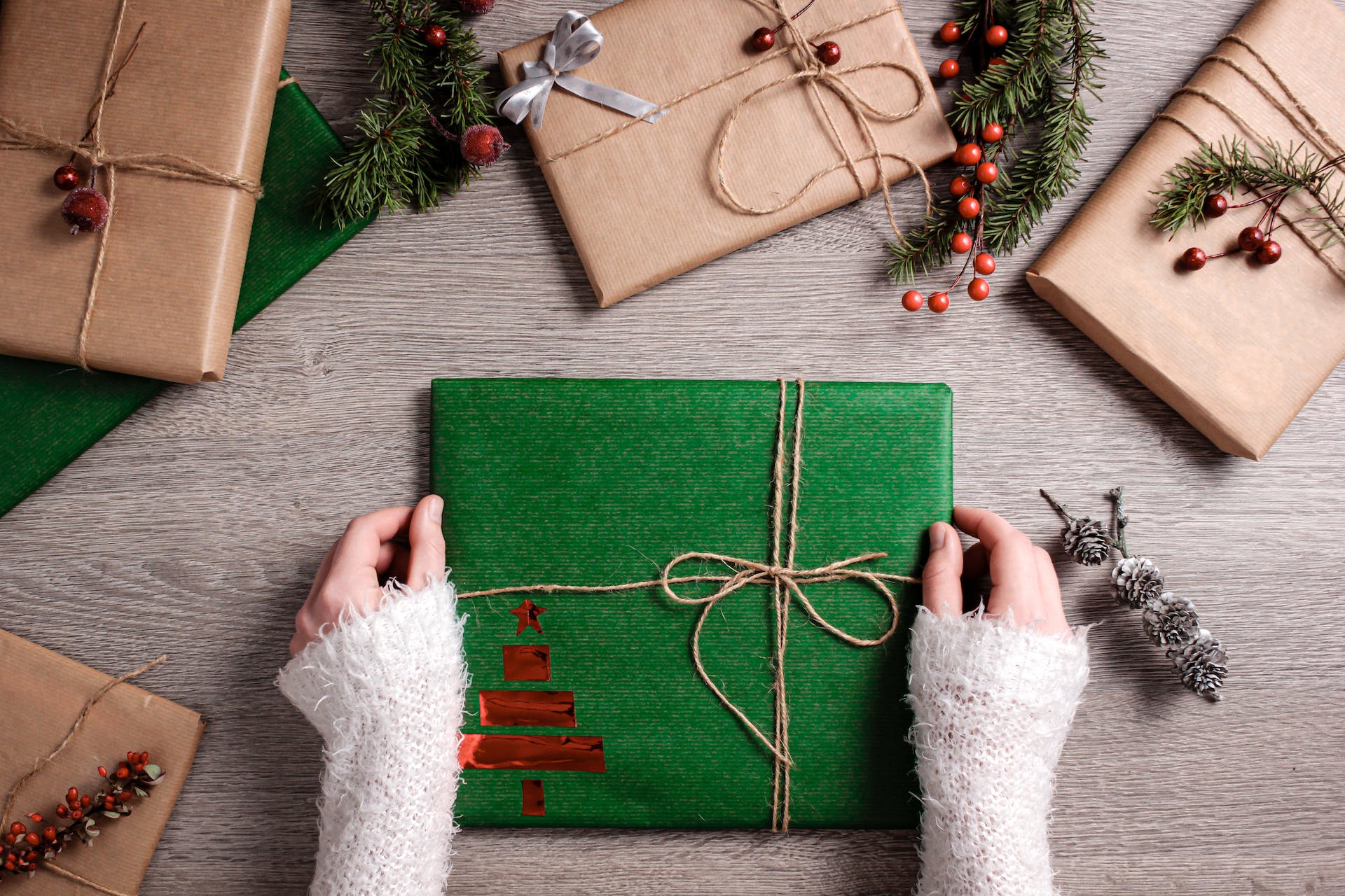 A woman holding a neatly wrapped holiday gift box | Source: Pexels