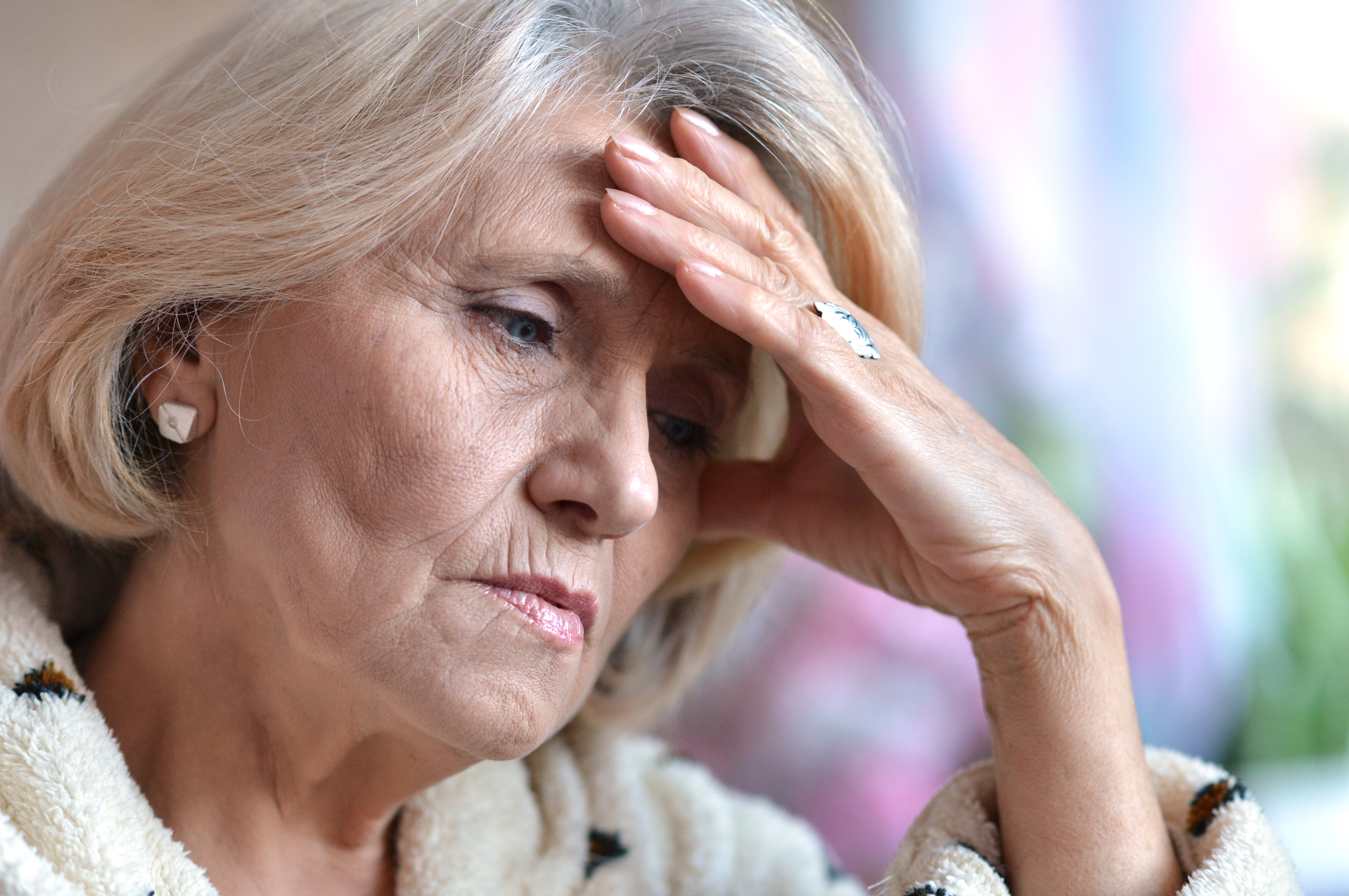 Sad elderly woman sitting in a room | Source: Shutterstock