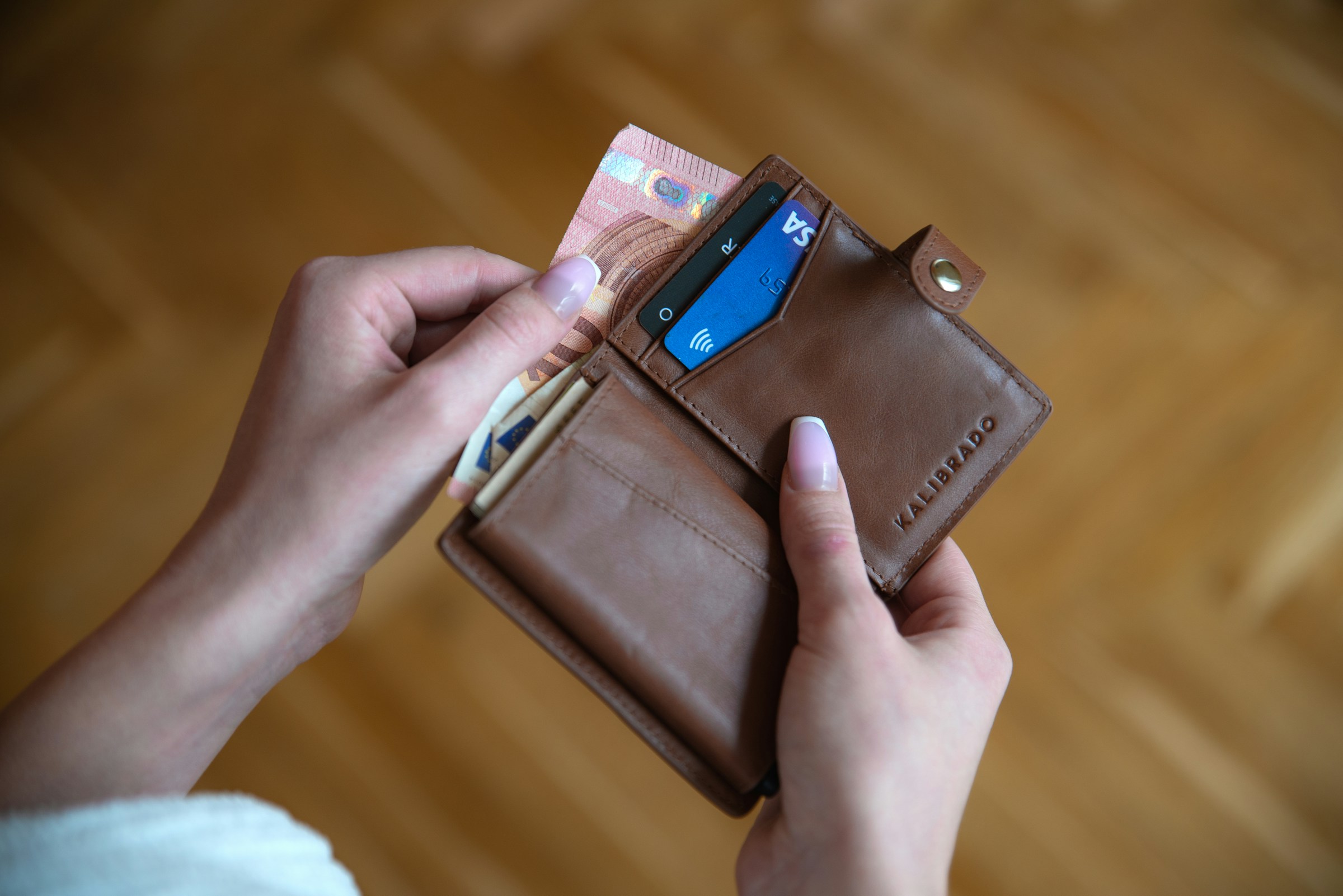 A woman holding a wallet | Source: Unsplash