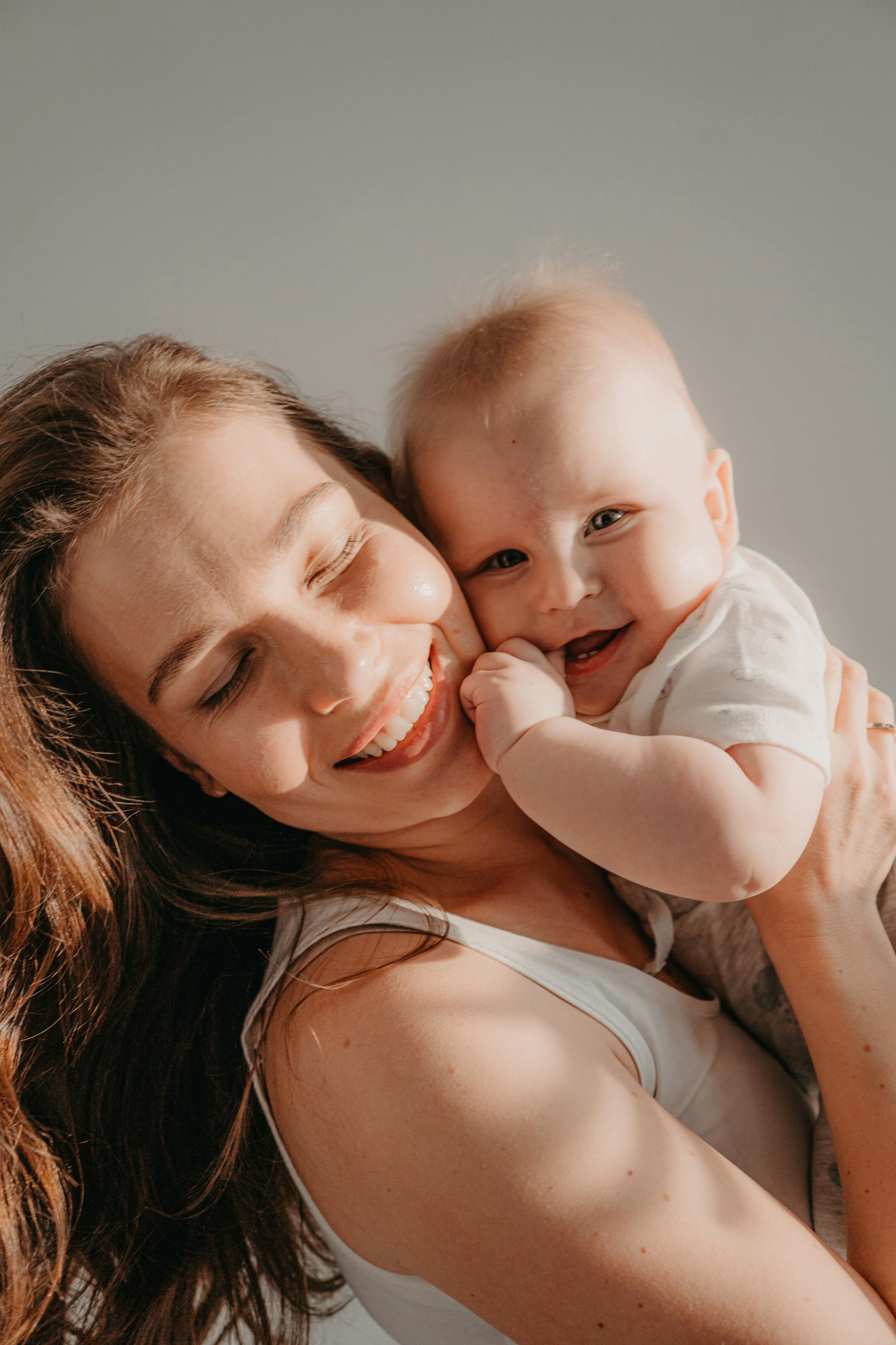 A happy woman holding a smiling baby | Source: Pexels