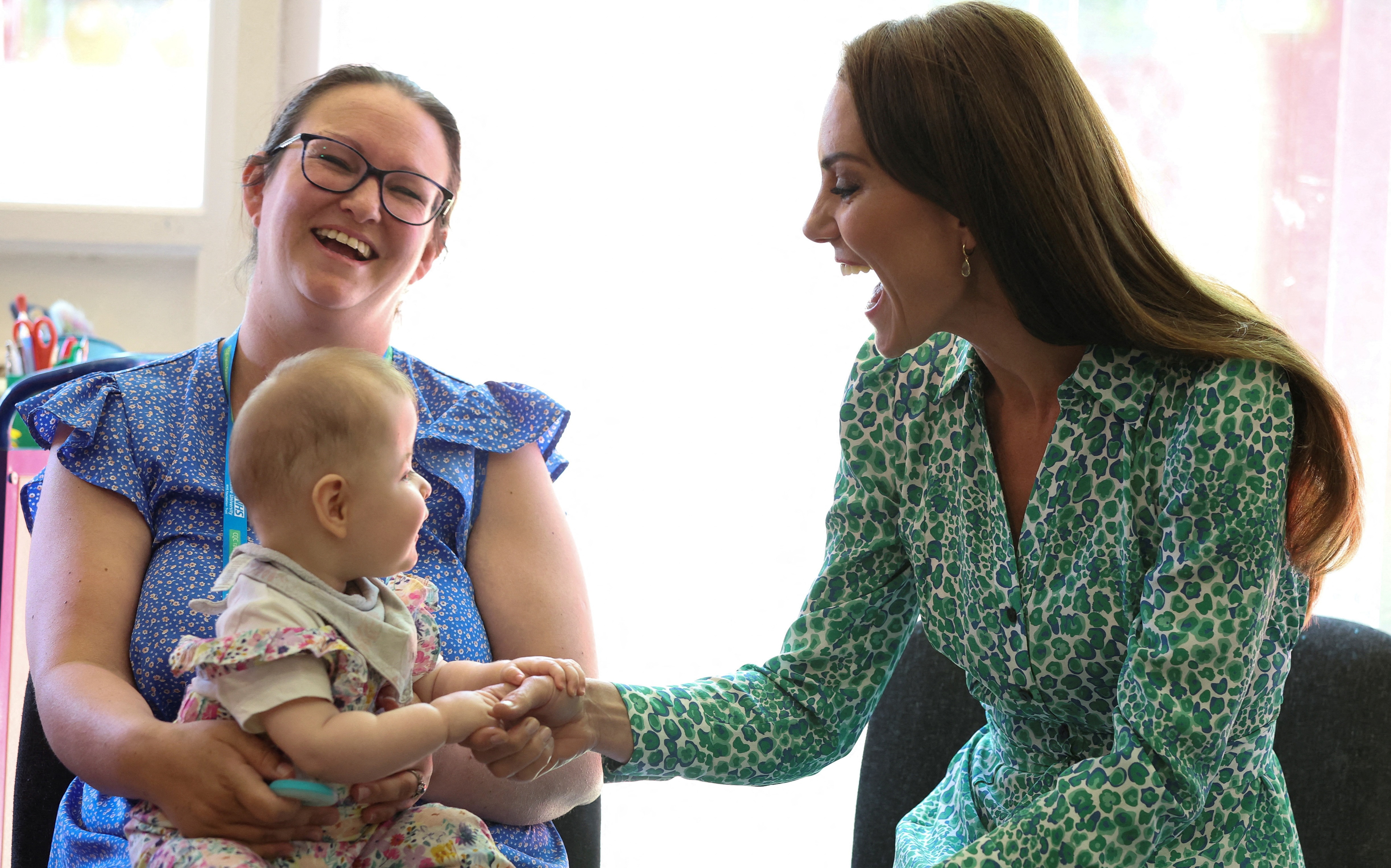 Catalina, Princesa de Gales, sostiene la mano de un bebé mientras se reúne con los visitantes sanitarios en el Centro de Salud Infantil Riversley Park en Nuneaton, el 15 de junio de 2023 | Fuente: Getty Images