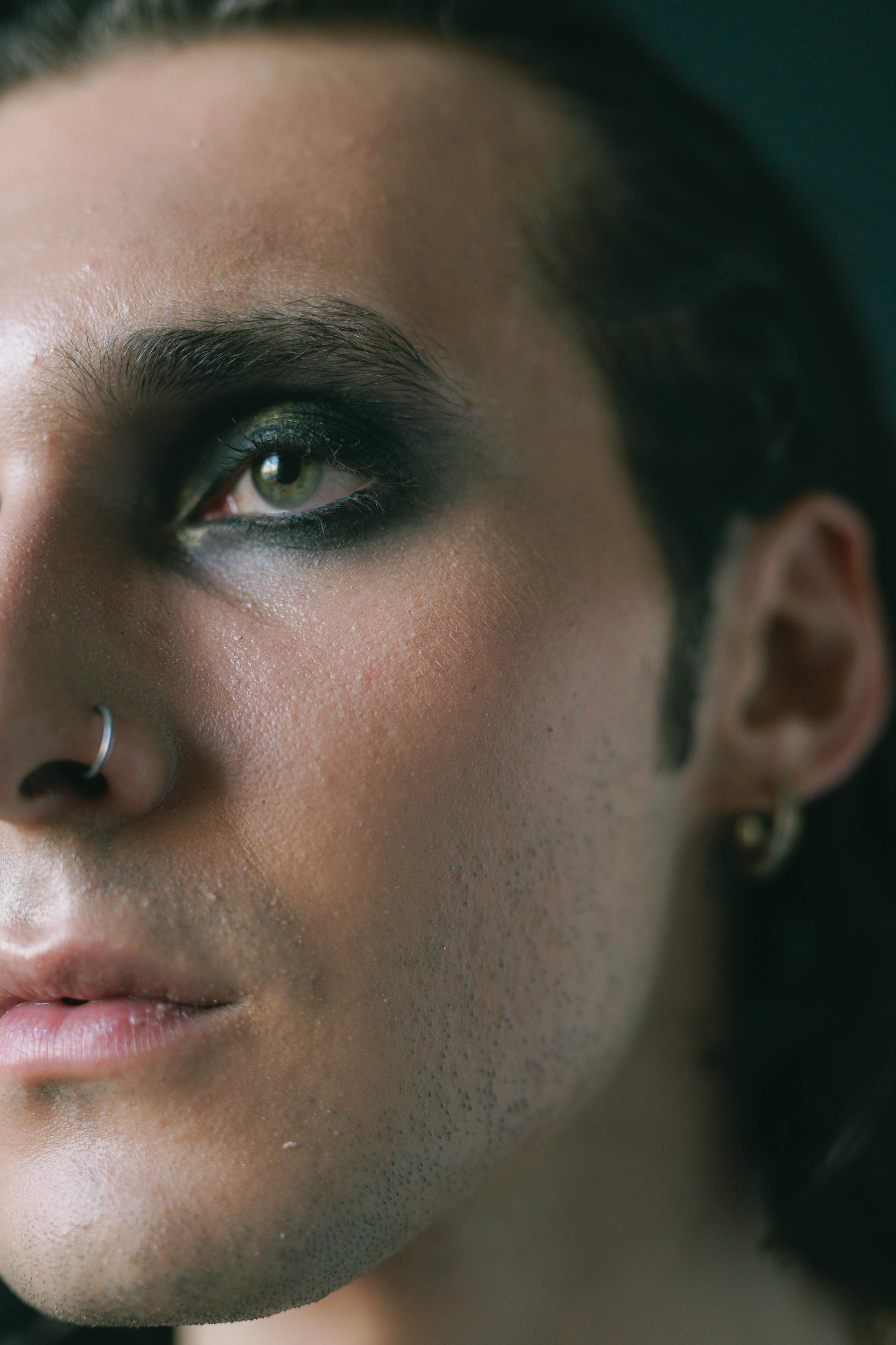 A close-up of a man with nose piercing and black eyeshadow | Source: Pexels