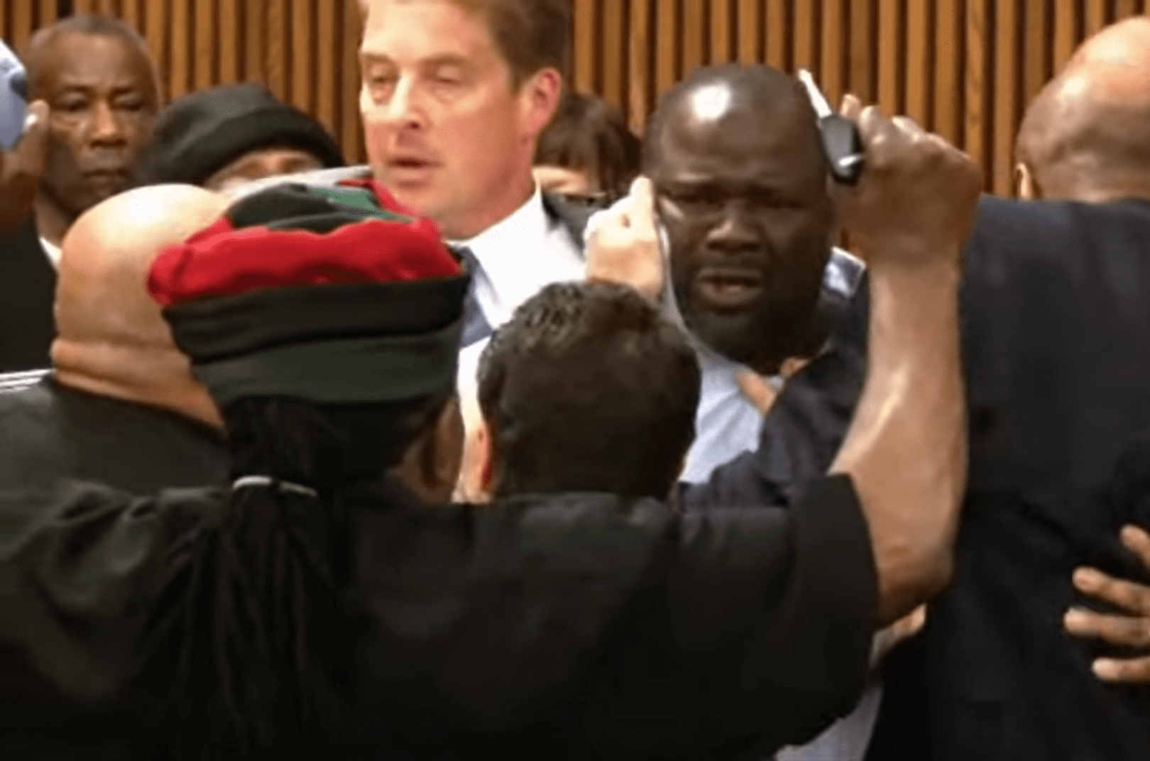 Bailiffs and court officials holding onto Van Terry as he looks confused and anguished.┃ Source: youtube.com/wsj