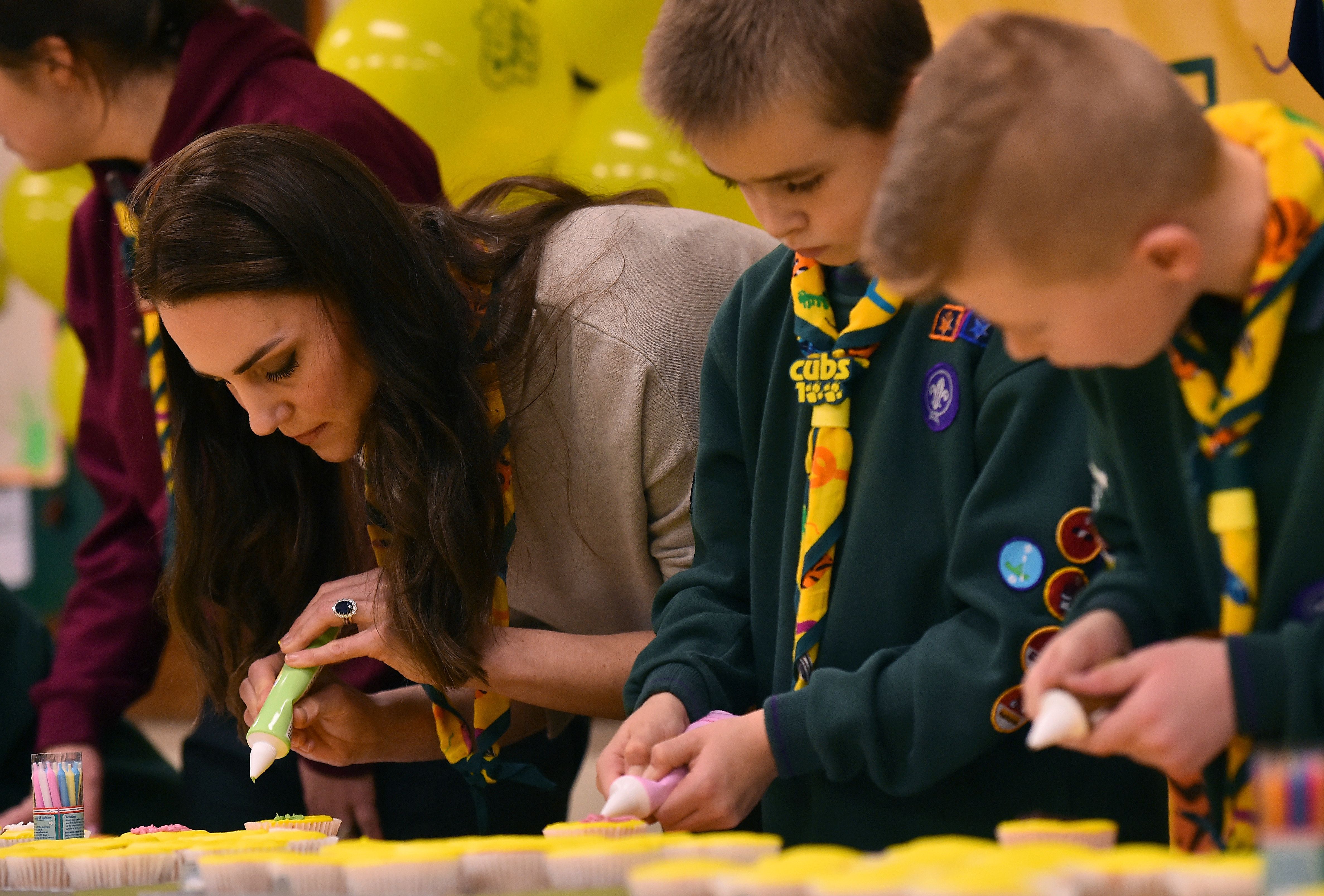 Kate Middleton icing a cupcake with members of the Cub Scout Pack during a Cub Scout Pack meeting in Kings Lynn, Eastern England on December 14, 2016 | Source: Getty Images