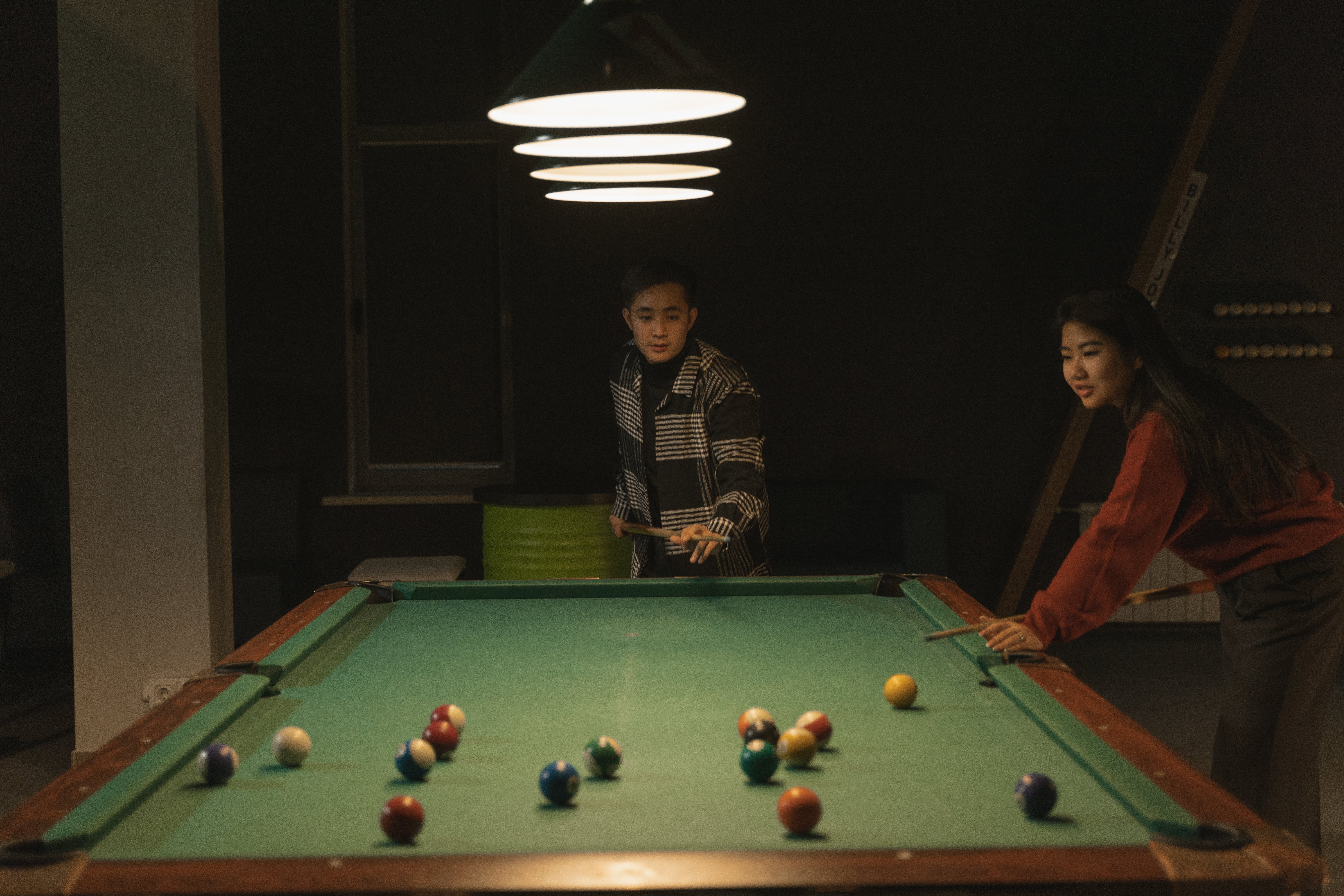 A man and a woman playing pool. | Source: Pexels