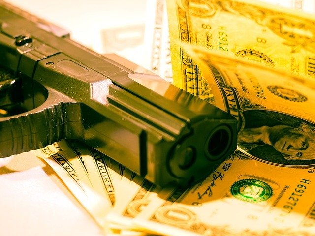 Photo of a gun and money | Photo: Pixabay