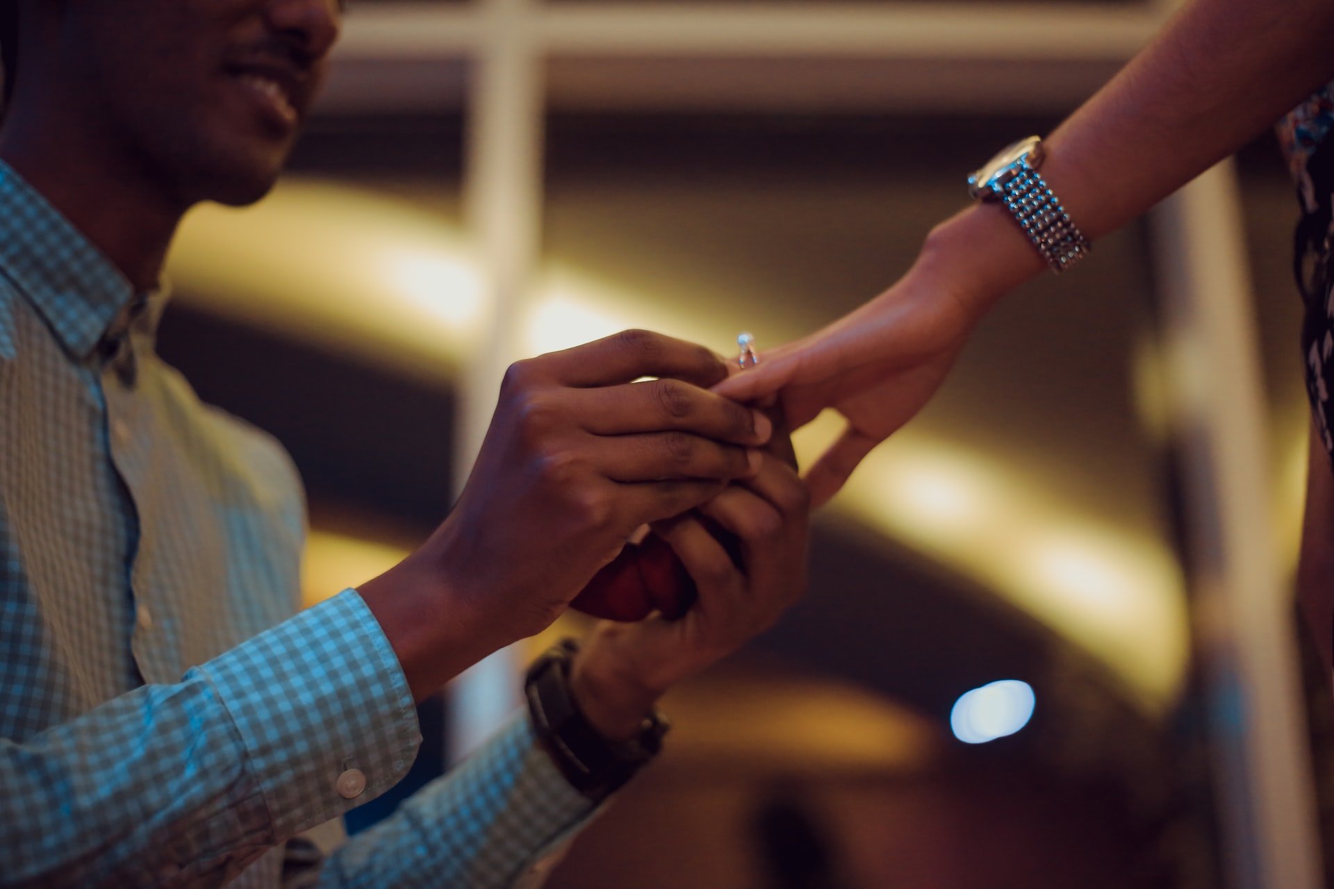 Un hombre pone un anillo de compromiso en el dedo de su novia. | Foto: Unsplash