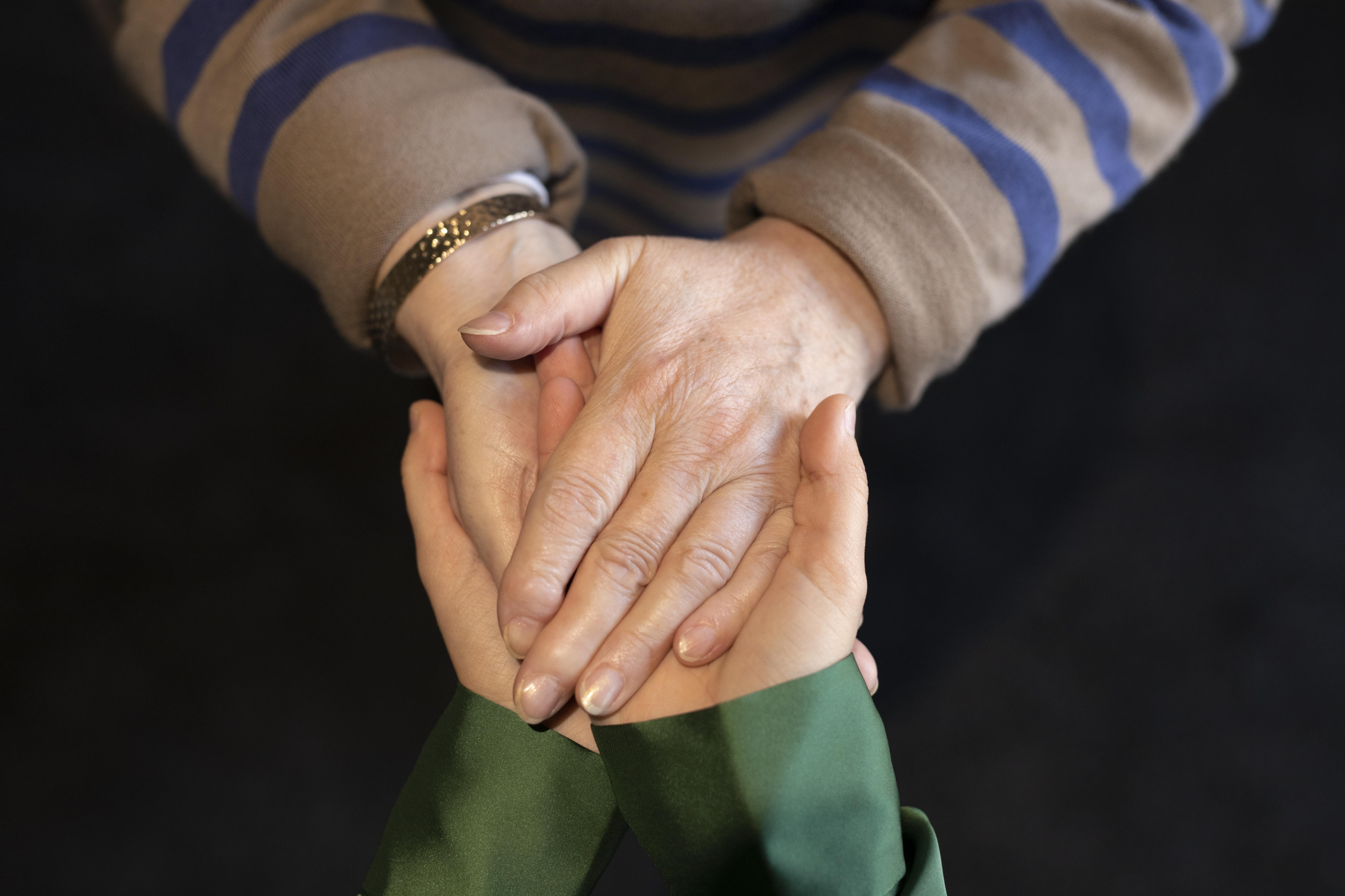 Young woman and older lady holding hands | Source: Freepik