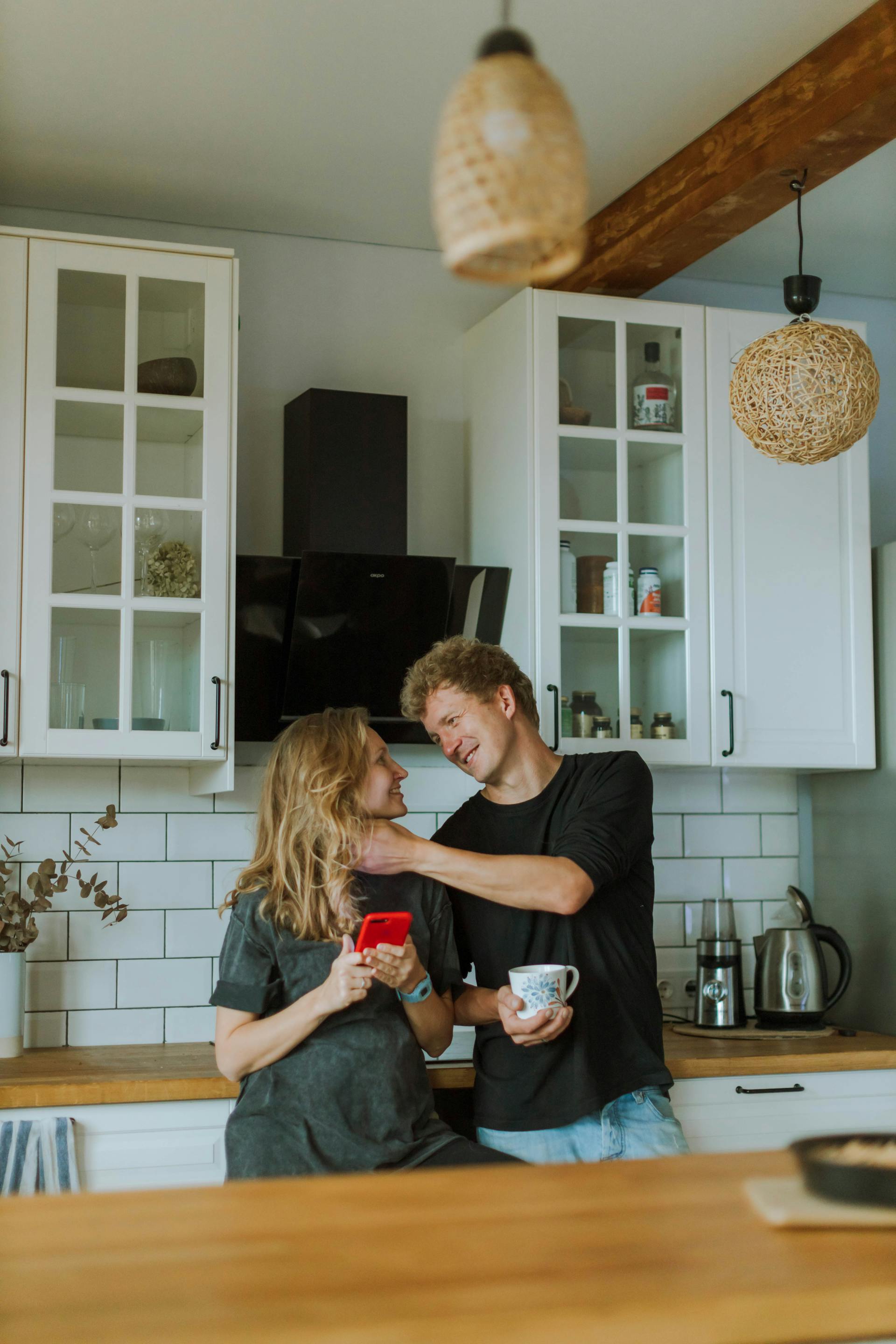 A couple sharing a sweet moment in the kitchen | Source: Pexels