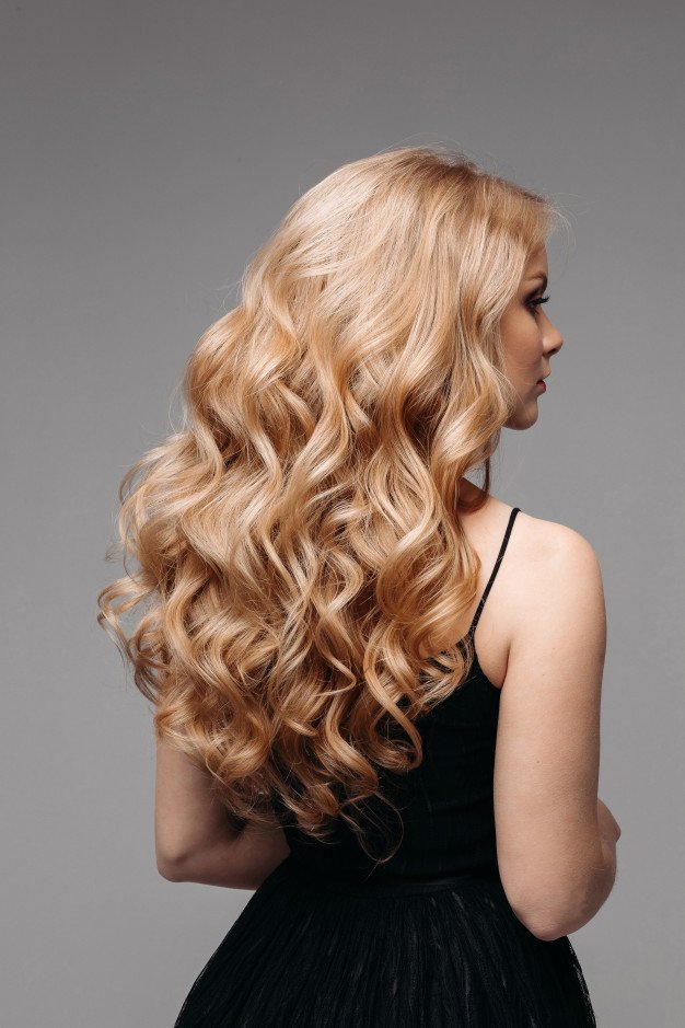 Mujer luciendo su larga melena rubia. │Foto: Freepik
