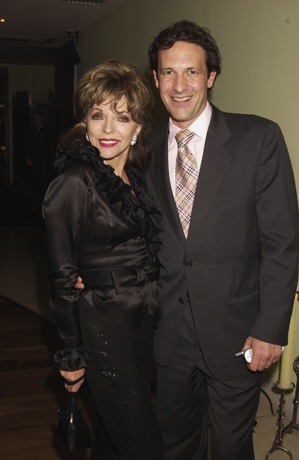 In 2002, Joan Collins and Percy Gibson were photographed together at a party. Their blossoming relationship continued to capture attention, with the couple displaying a strong bond early on. | Source: Getty Images