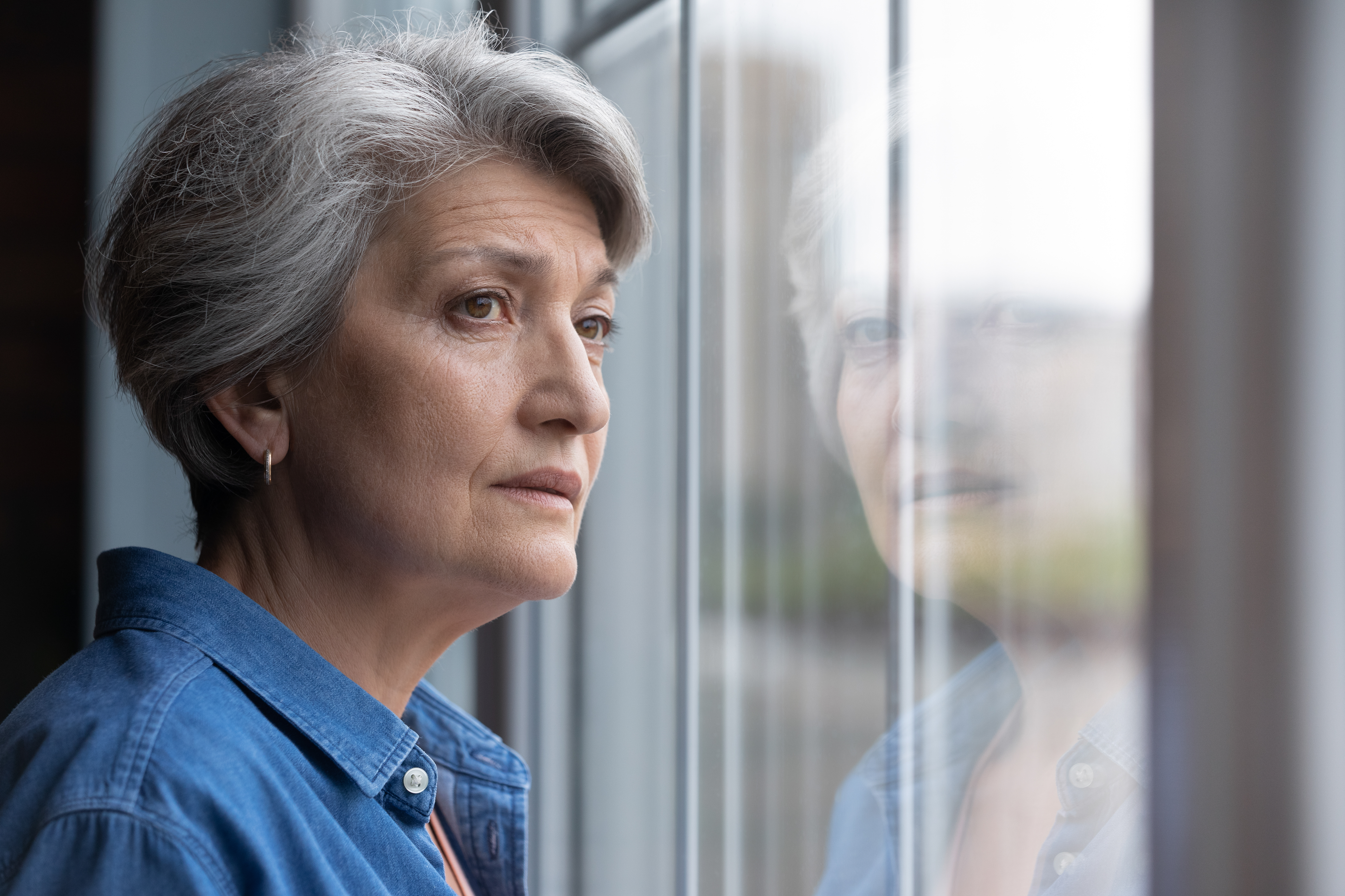 A woman looking out the window while contemplating something | Source: Shutterstock