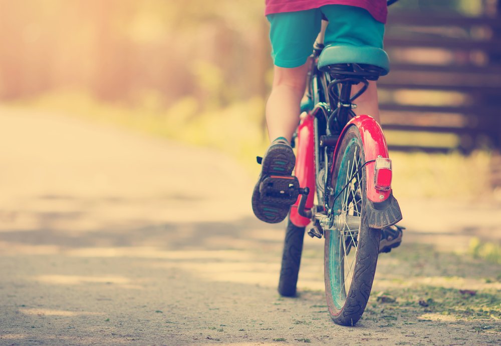 Niño manejando bicicleta a la luz del día. Fuente: Shutterstock