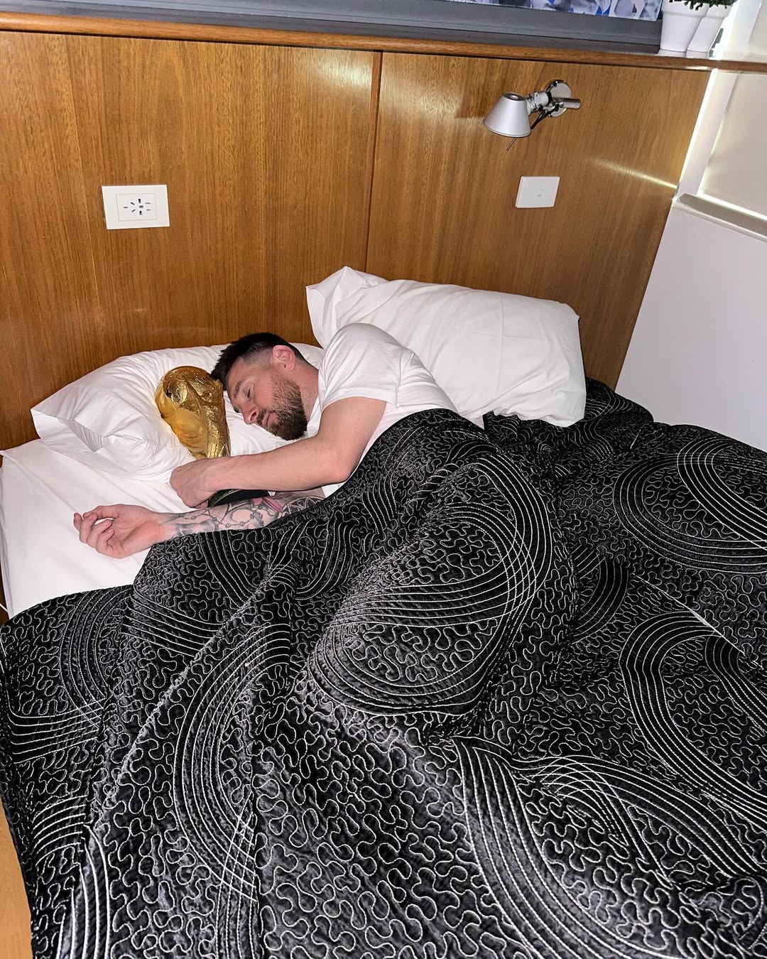 Lionel Messi pictured with a trophy in bed, dated December 2022 | Source: Instagram/leomessi