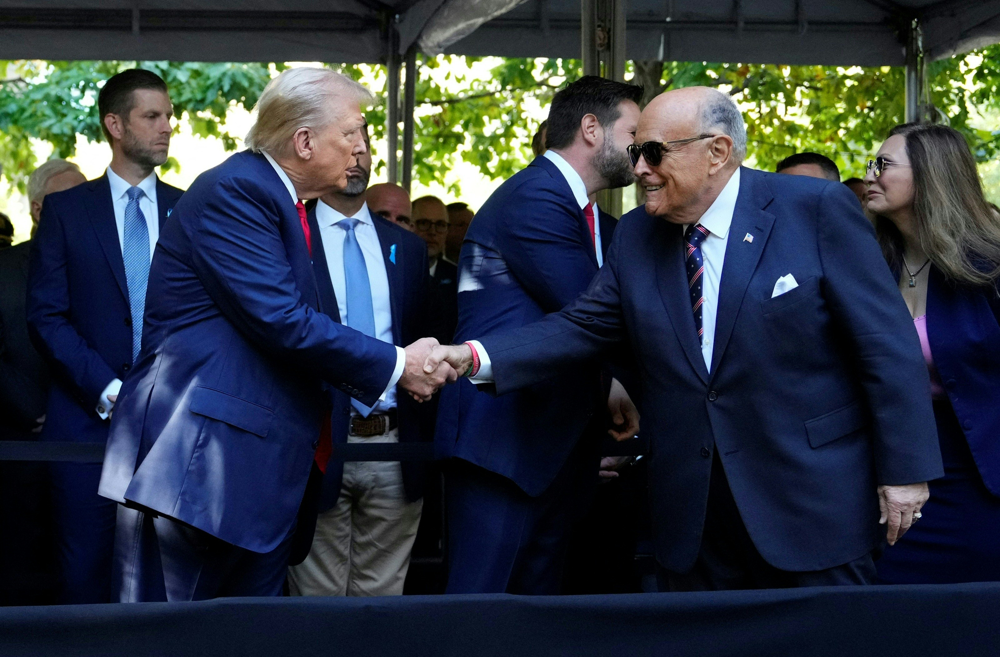 Donald Trump shakes hands with Rudy Giuliani in New York City on September 11, 2024 | Source: Getty Images