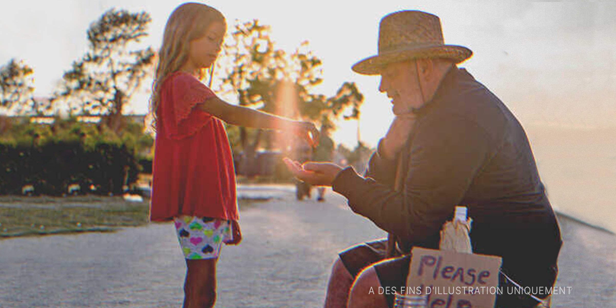 Une petite fille donnant l'aumône à un homme âgé | Getty Images