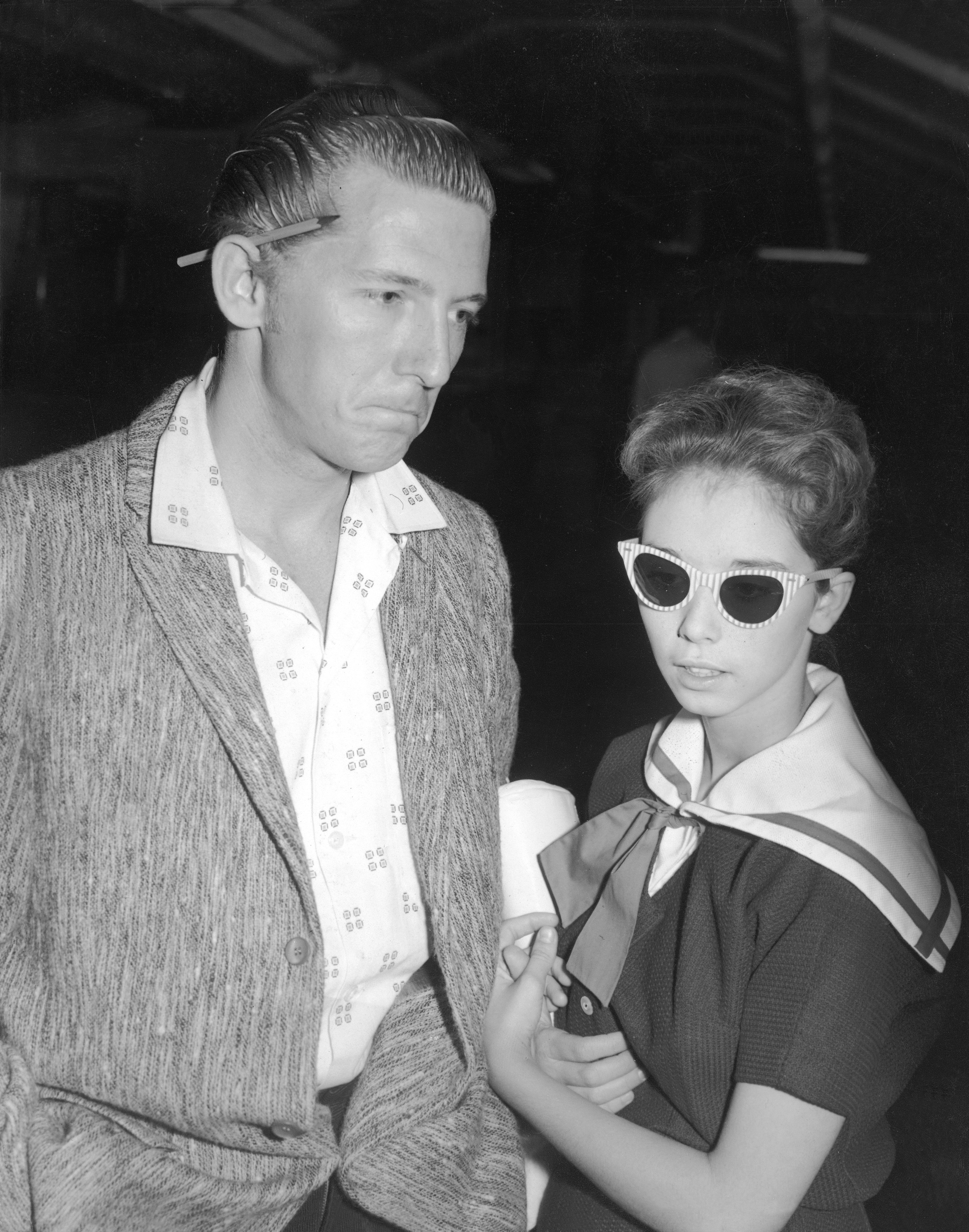 Jerry Lee Lewis with his wife at the airport as they prepare to leave the United Kingdom after the cancellation of his tour in the wake of the uproar caused by the revelation of his marriage to his 13-year-old cousin, London, May 27, 1958. | Source: Getty Images