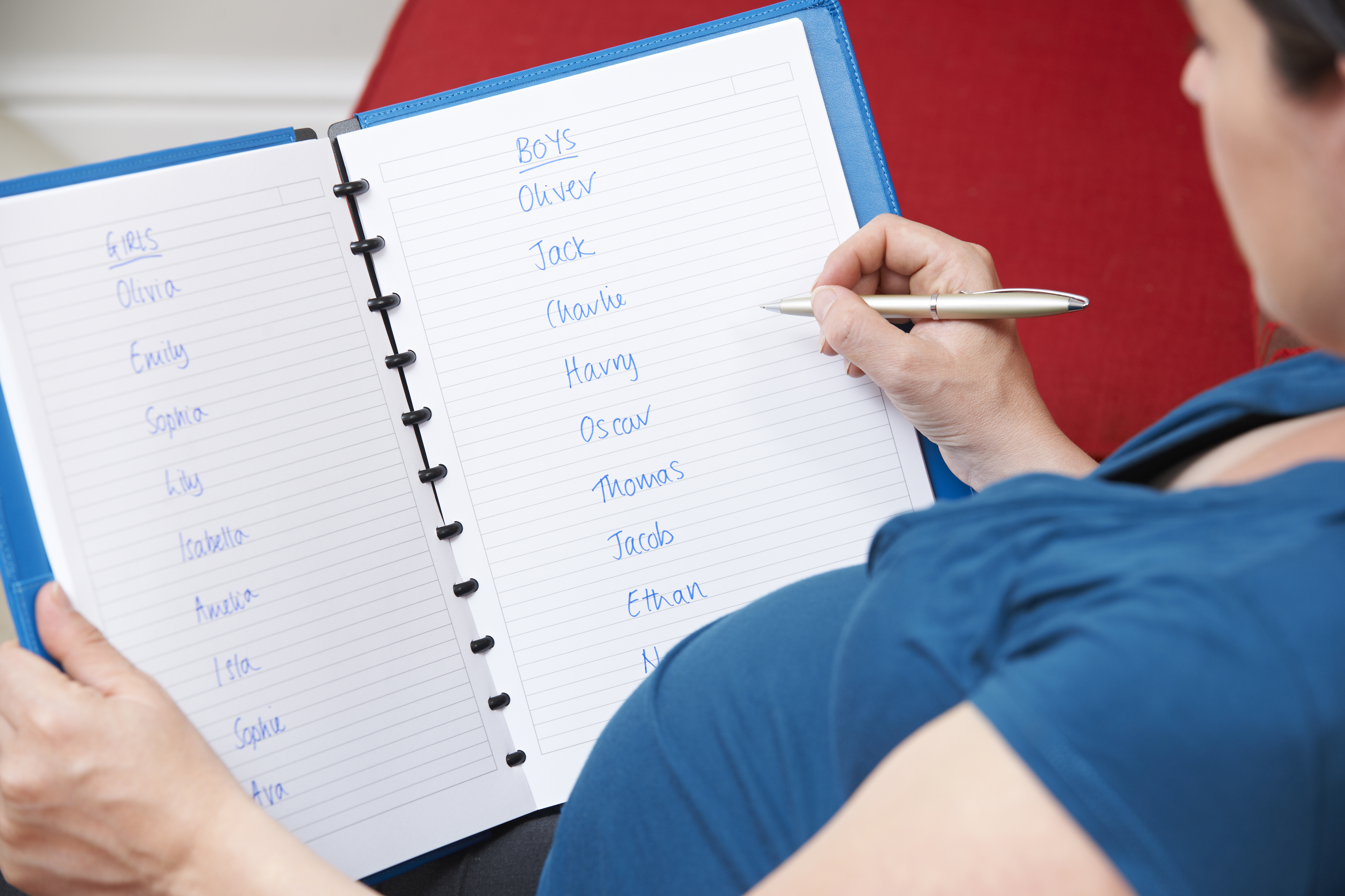 A pregnant woman writing down potential baby names | Source: Shutterstock