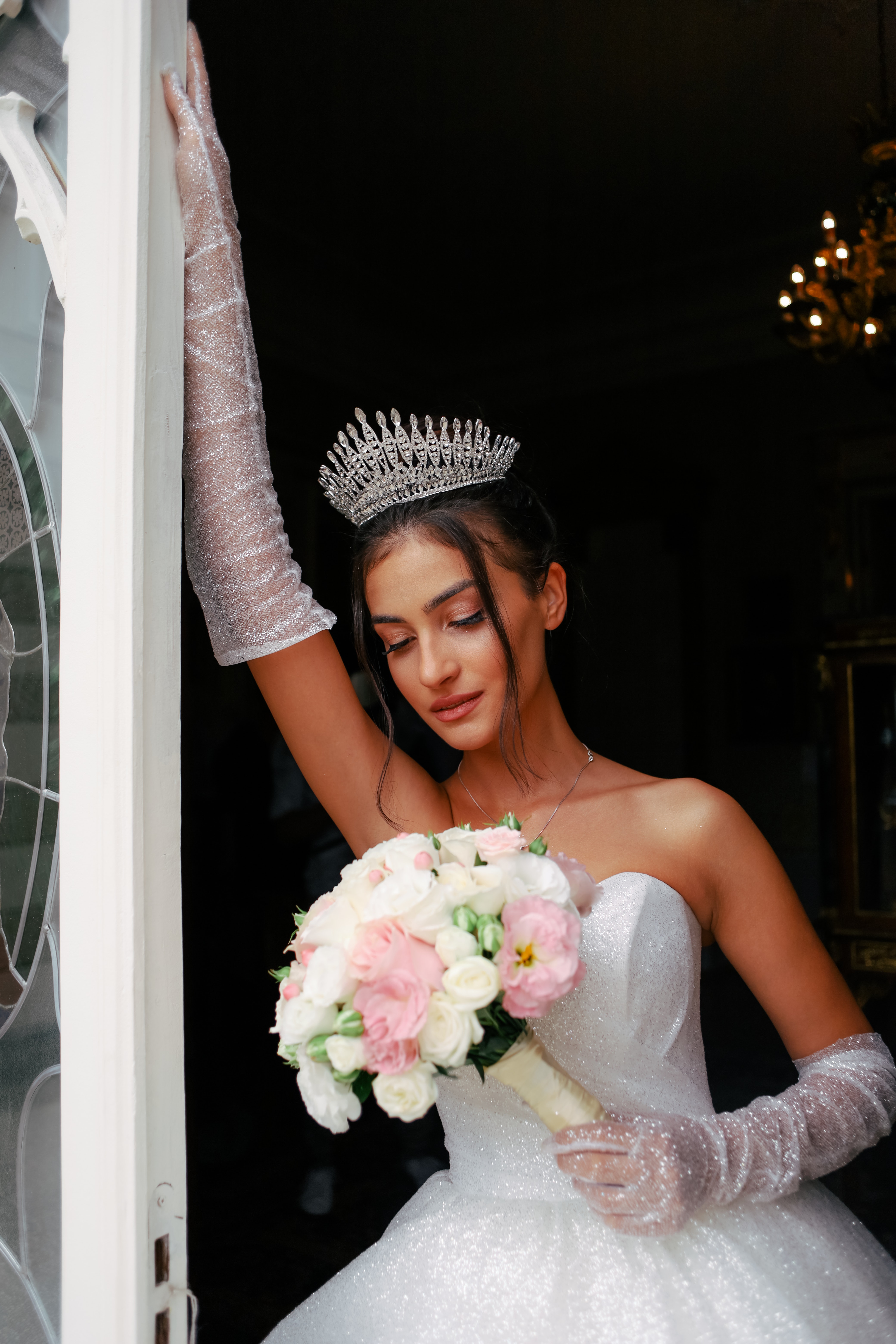Brunette bride in white bustier dress and gloves posing in a doorway | Source: Pexels