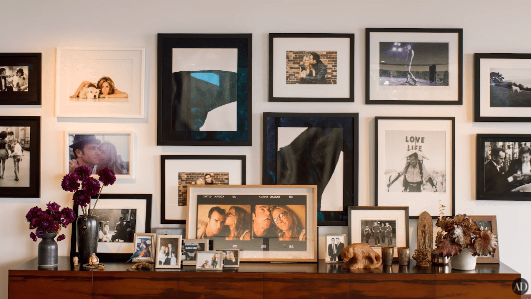 Shelf and wall frames inside Jennifer Aniston and Justin Theroux's LA home. | Photo: YouTube/Architectural Digest