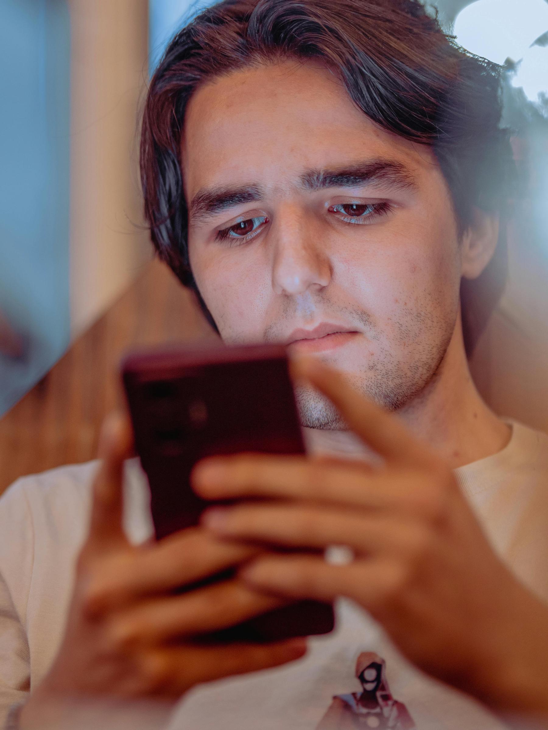 Michael distractedly scrolling through his phone | Source: Pexels