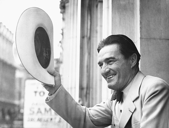 Actor Tom Mix seen waving his cowboy hat from the balcony of the London Palladium on August 31st 1938. | Photo: Getty Images