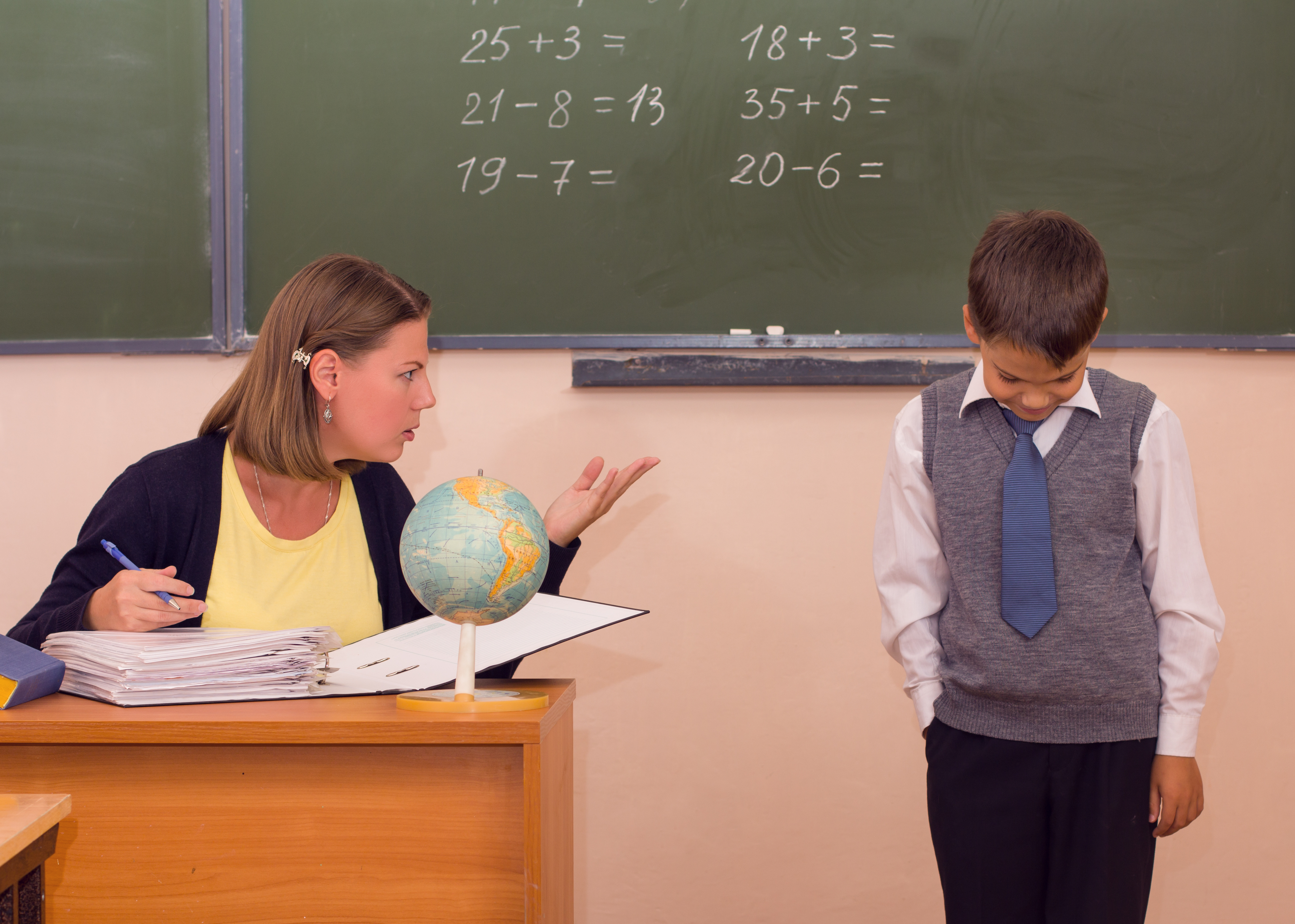 A teacher scolding a boy in front of the class | Source: Shutterstock