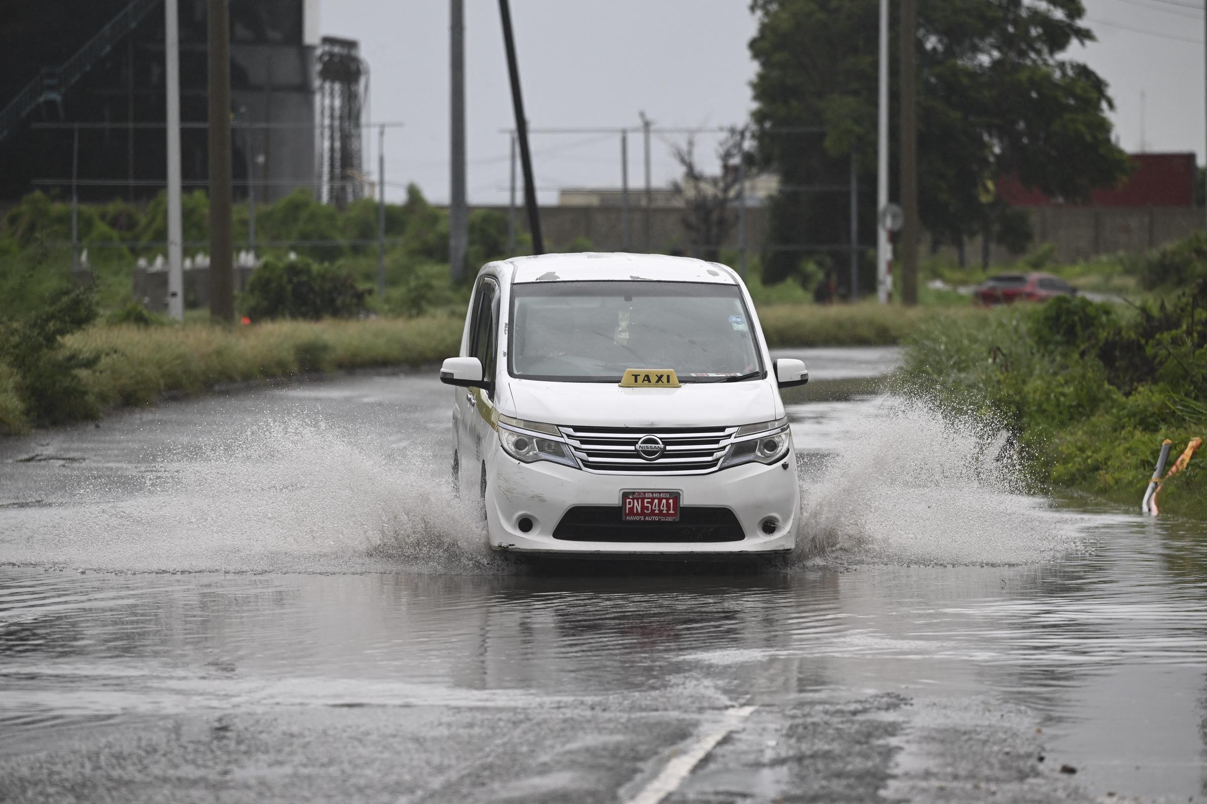 A motorist drives along flooded Michael Manley Boulevard in Kingston, Jamaica. | Source: Getty Images