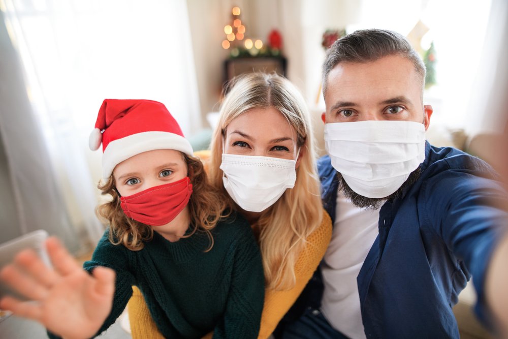 Familia celebrando la Navidad con mascarillas. | Foto: Shutterstock