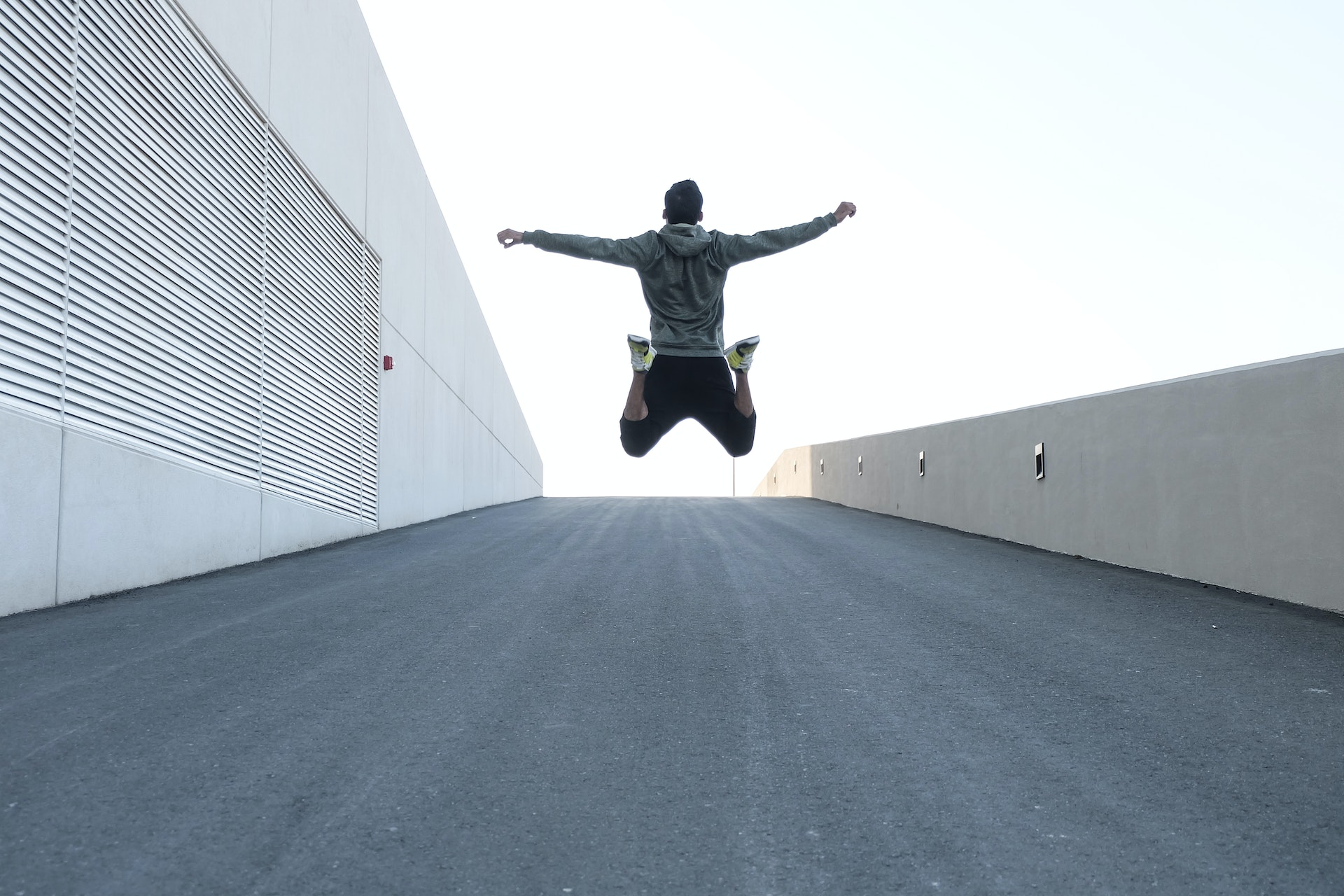 A man jumps in the air with open arms | Source: Pexels