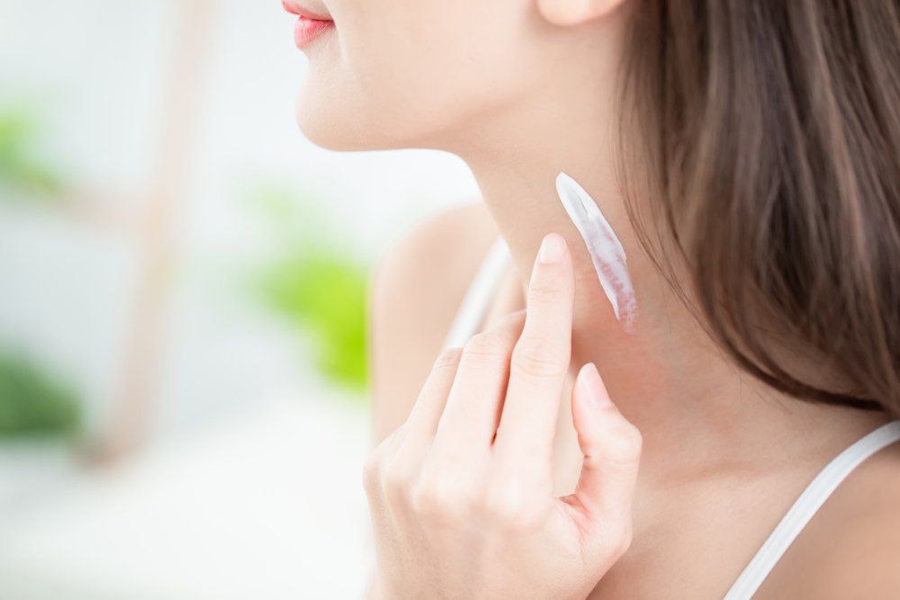 Mujer aplicando protector solar en el cuello. | Foto: Shutterstock