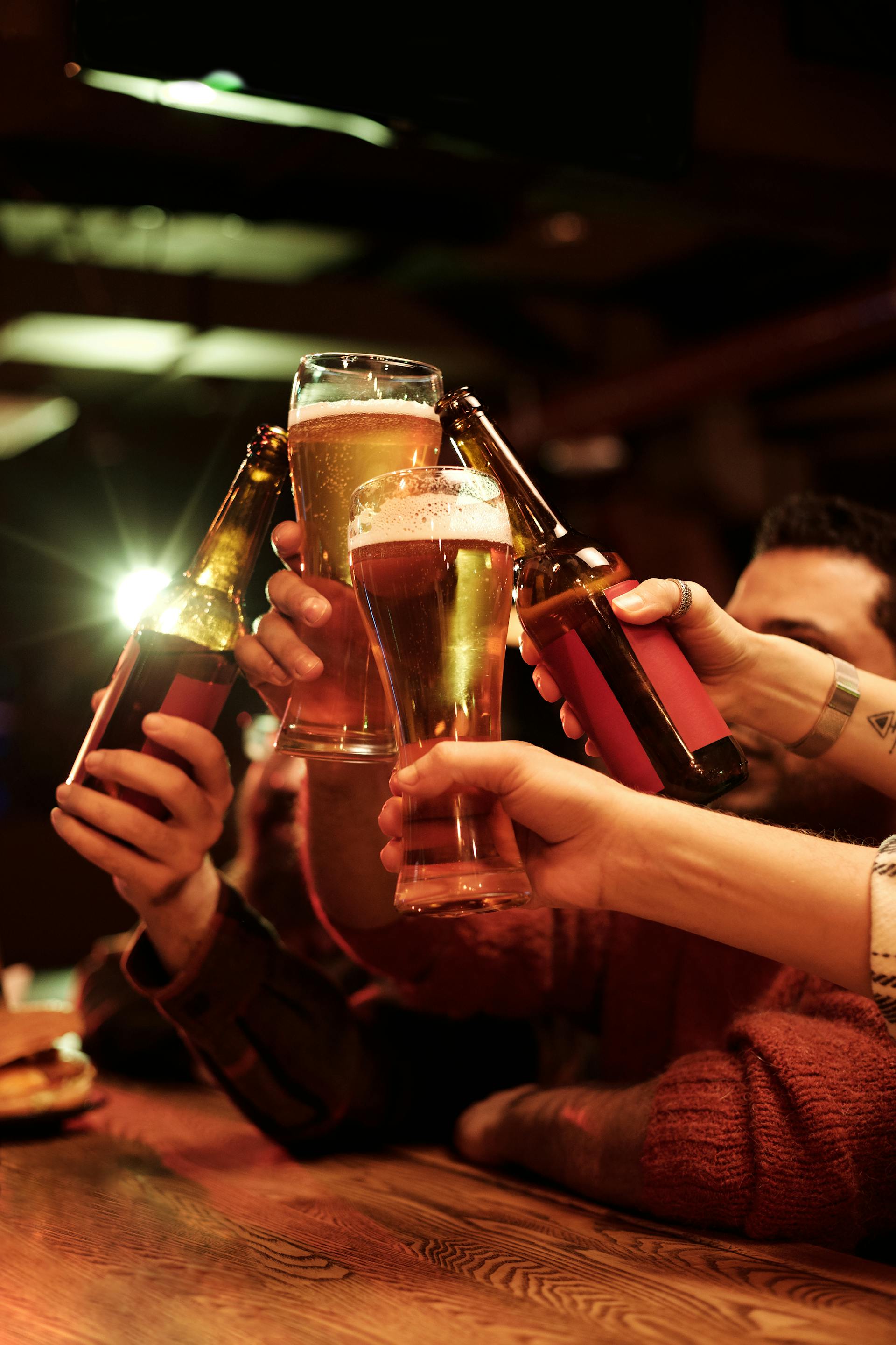 A group of men clinking their glasses of beer together | Source: Pexels