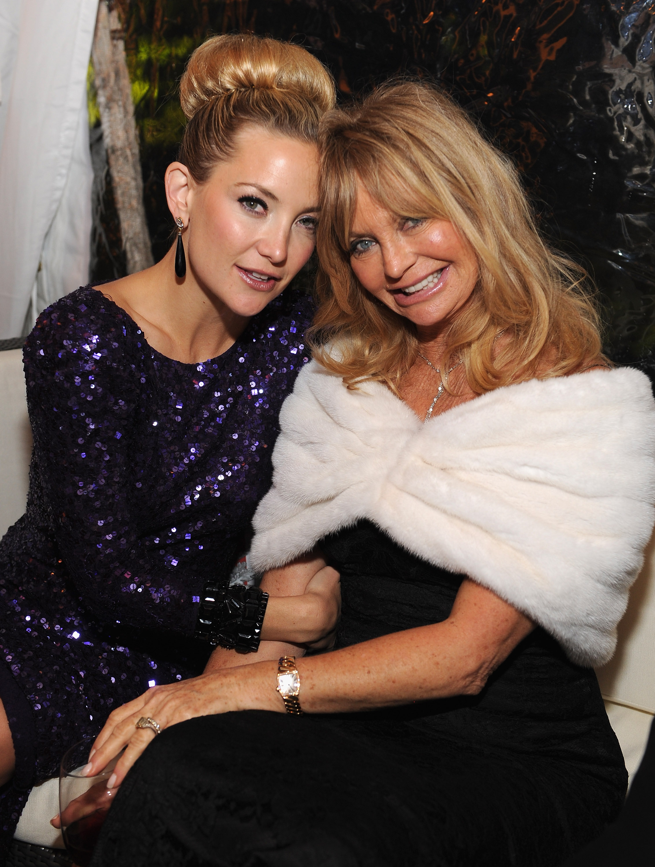 Goldie Hawn and Kate Hudson pose at the Bloomberg & Vanity Fair reception following the 2012 White House Correspondents' Dinner. Seated close, they exude warmth: Hudson in deep purple sequins, Hawn in black with a white wrap.