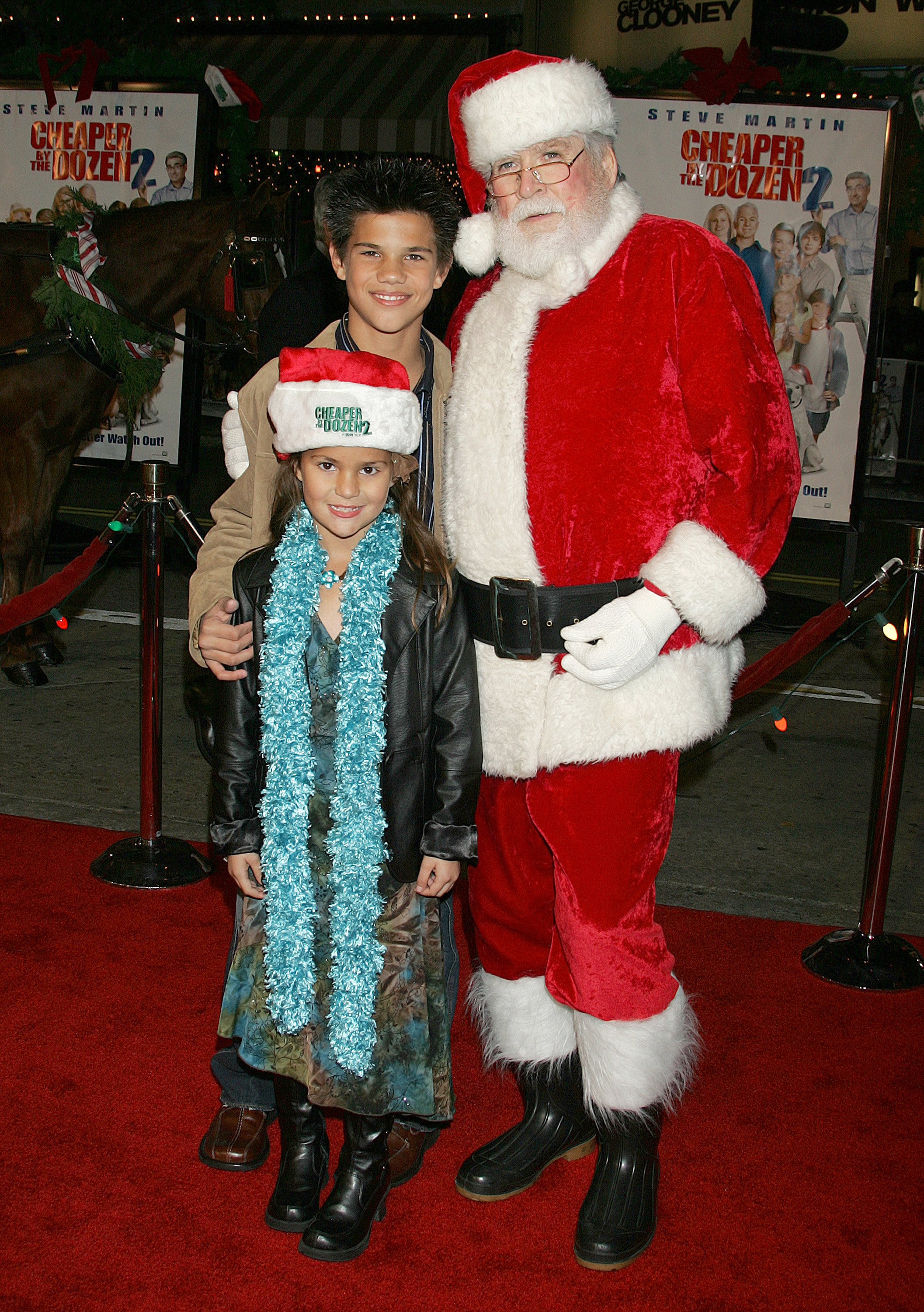 Taylor Lautner, McKenna Lautner and Santa Claus pose at the Mann Village Theatre on an unspecified date in Westwood, California | Source: Getty Images