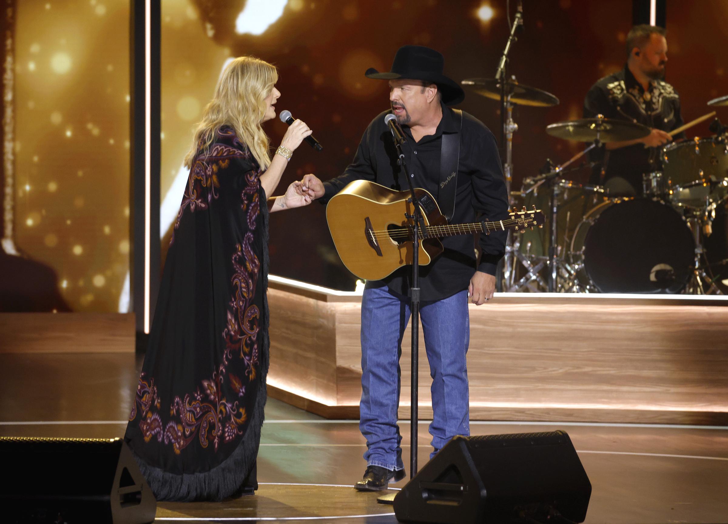 Trisha Yearwood and Garth Brooks perform onstage "Opry 100: A Live Celebration" at Grand Ole Opry in Nashville, Tennessee, on March 19, 2025 | Source: Getty Images