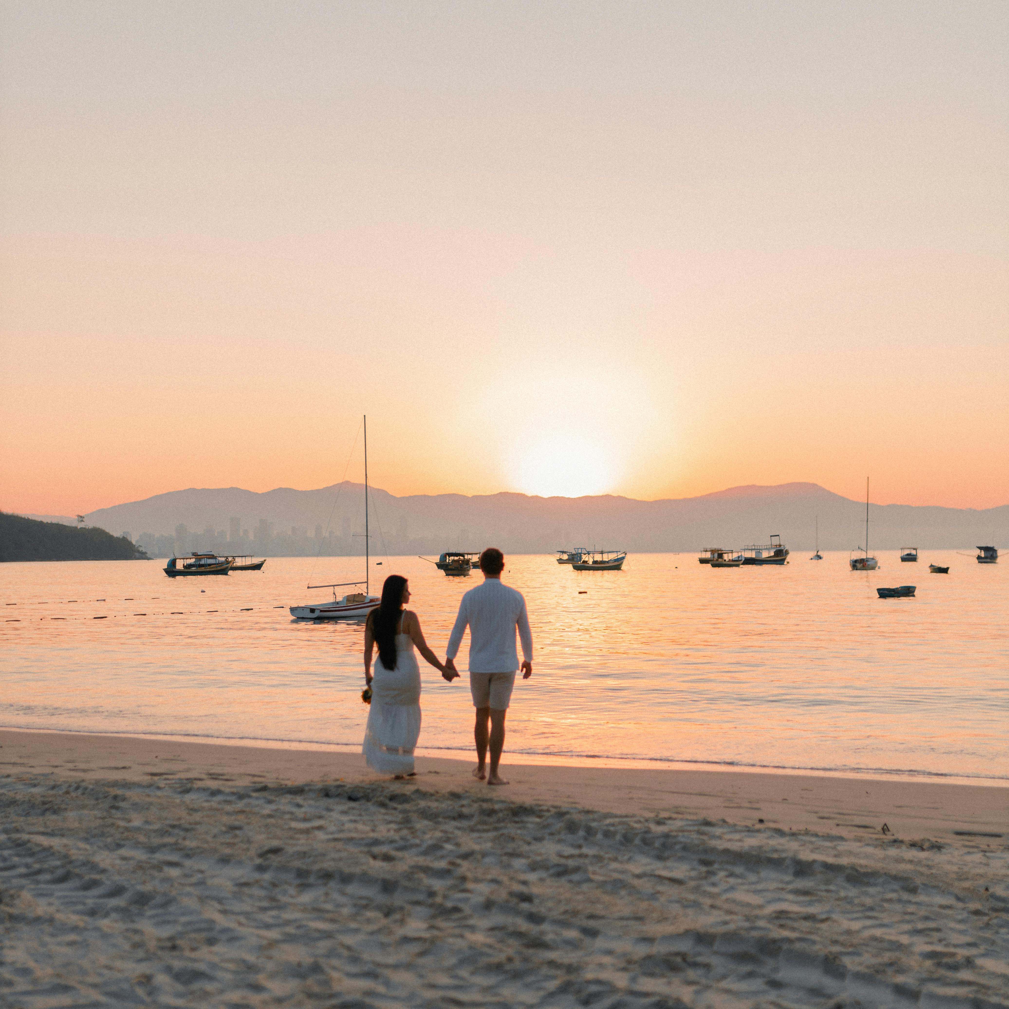 A couple walking on a beach, holding hands | Source: Pexels