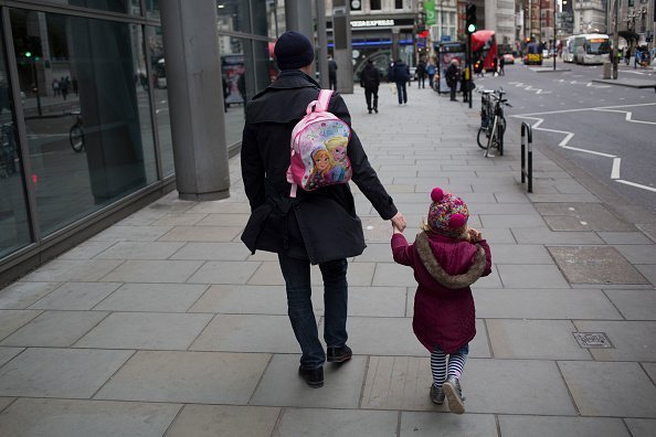 Father carries his daughter's Anna and Elsa Frozen backpack | Photo: Getty Images