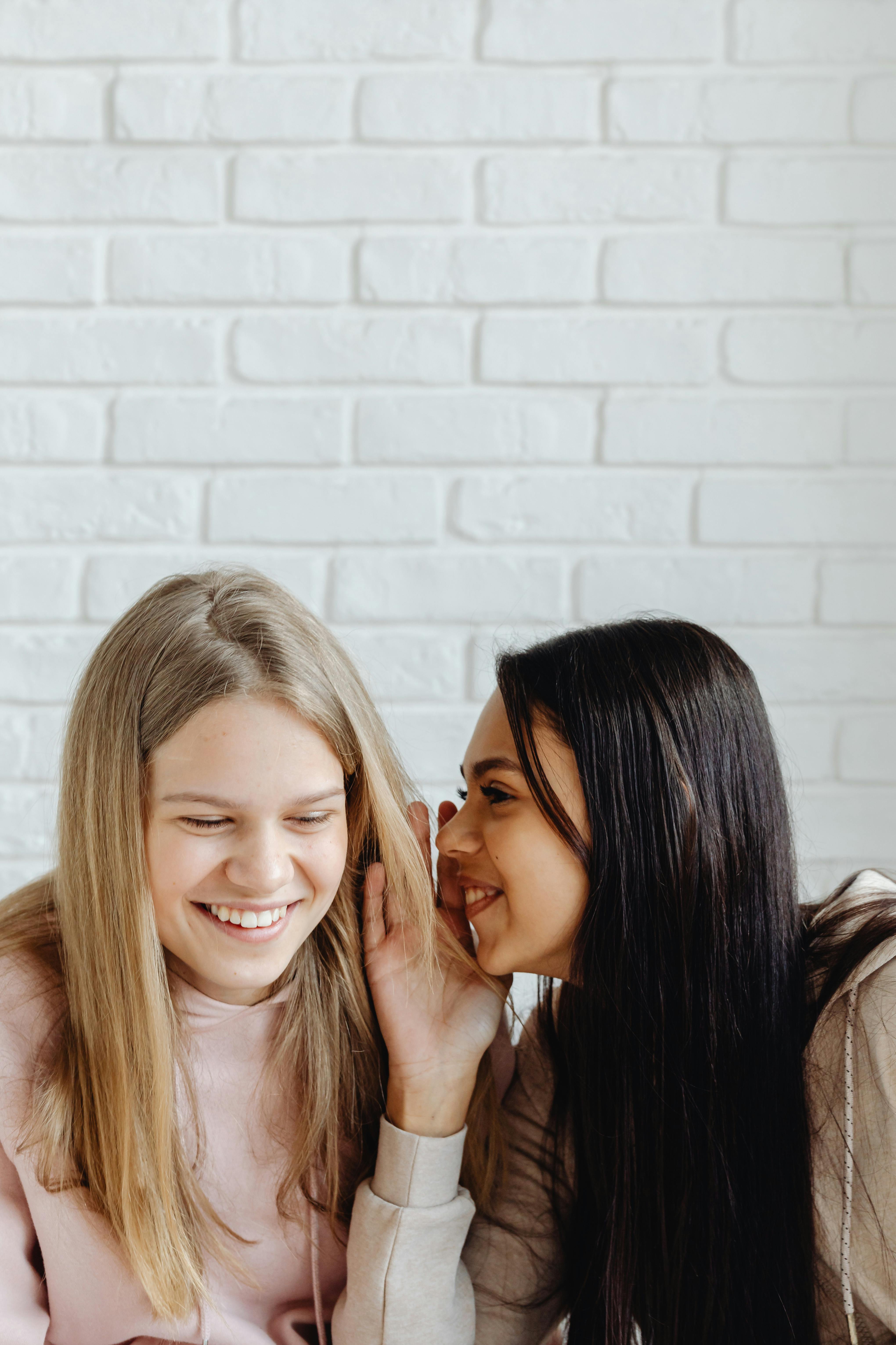 Two young women whispering | Source: Pexels