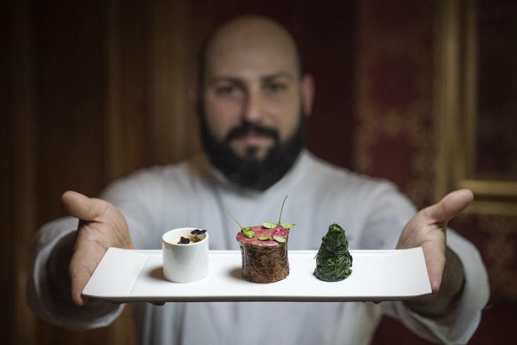 Chef carrying a plate of food | Photo: Getty Images