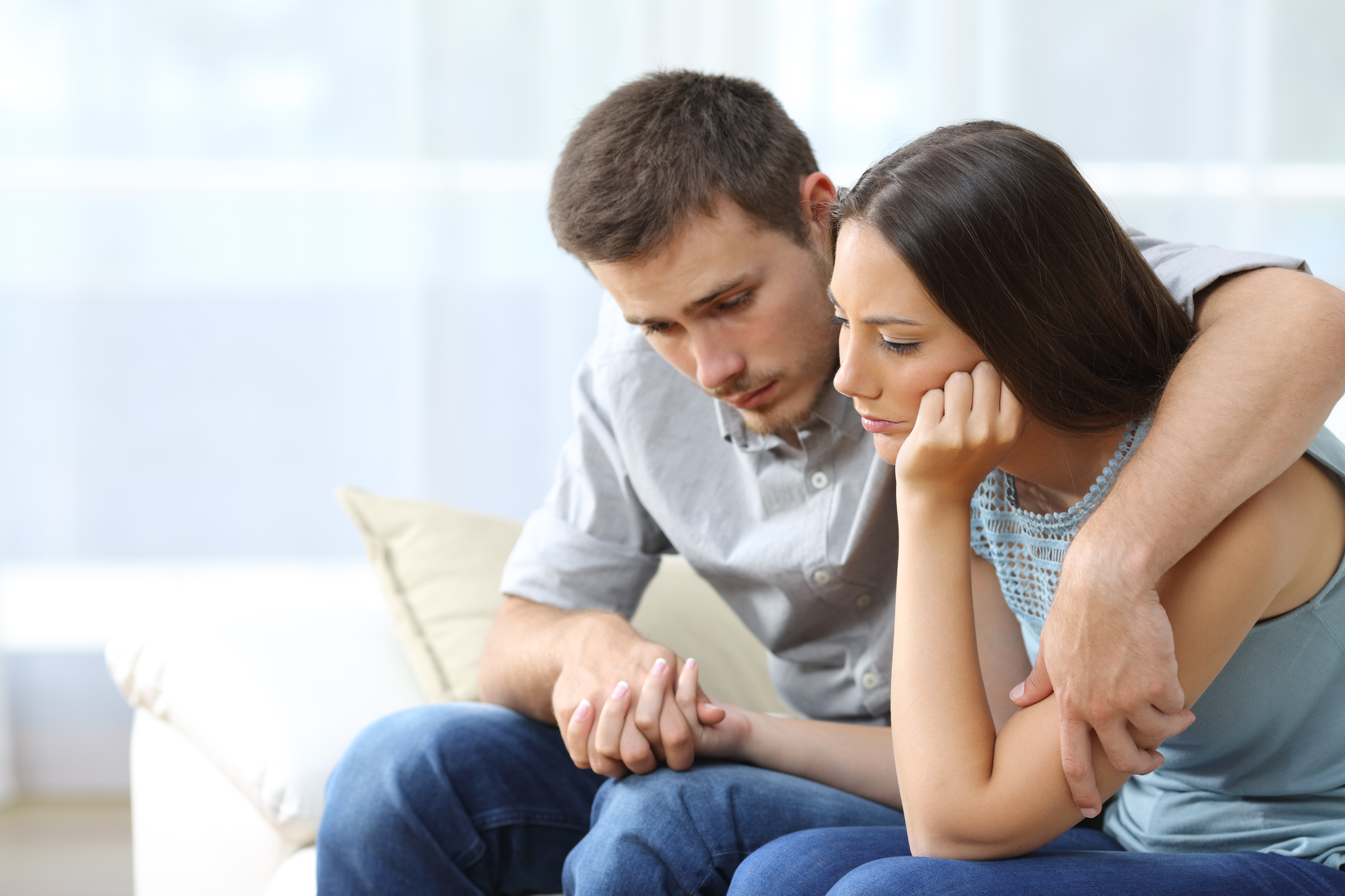 A sad couple comforting each other | Source: Shutterstock
