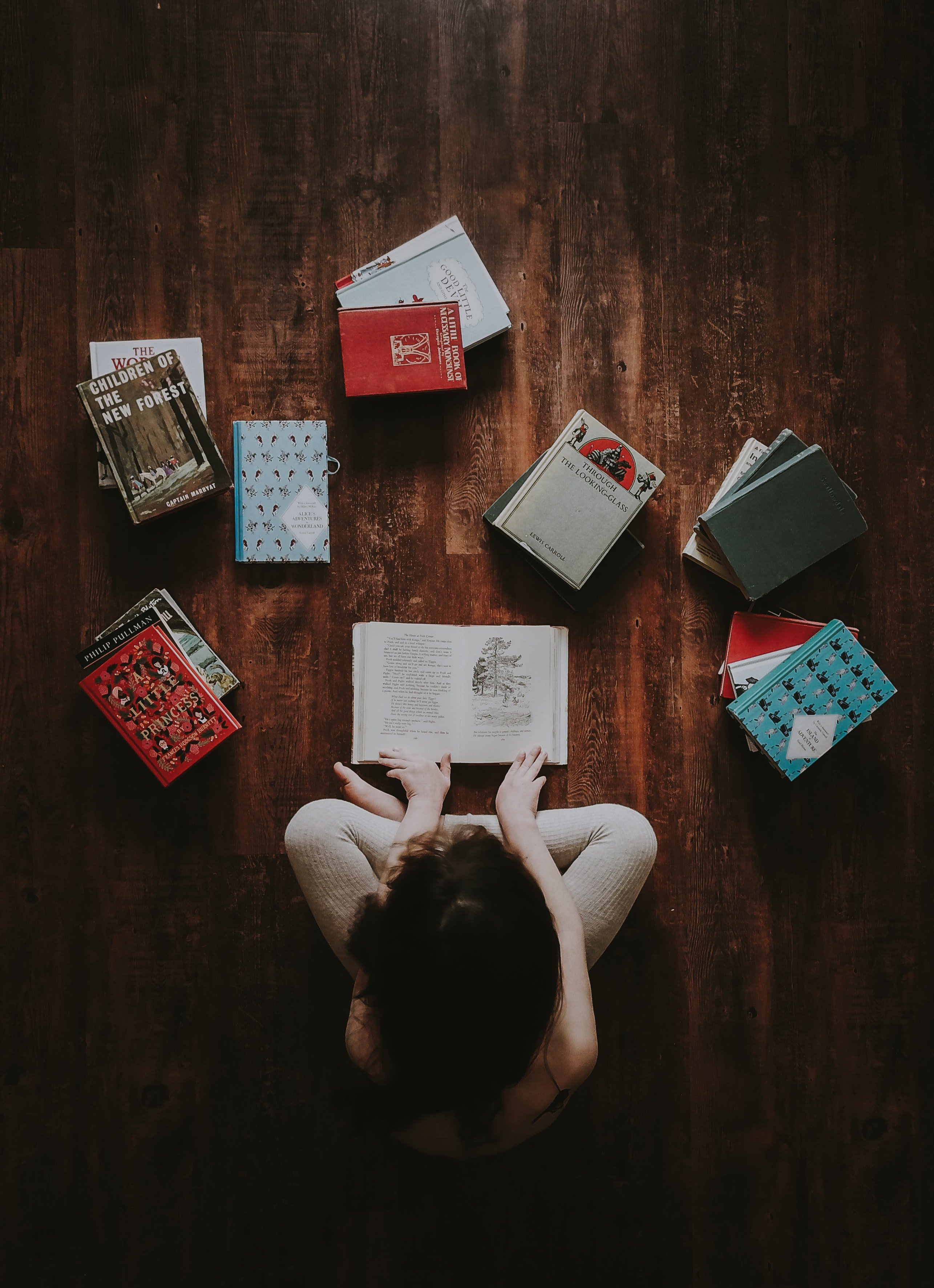 Boy sitting on the floor with books | Source: Unsplash
