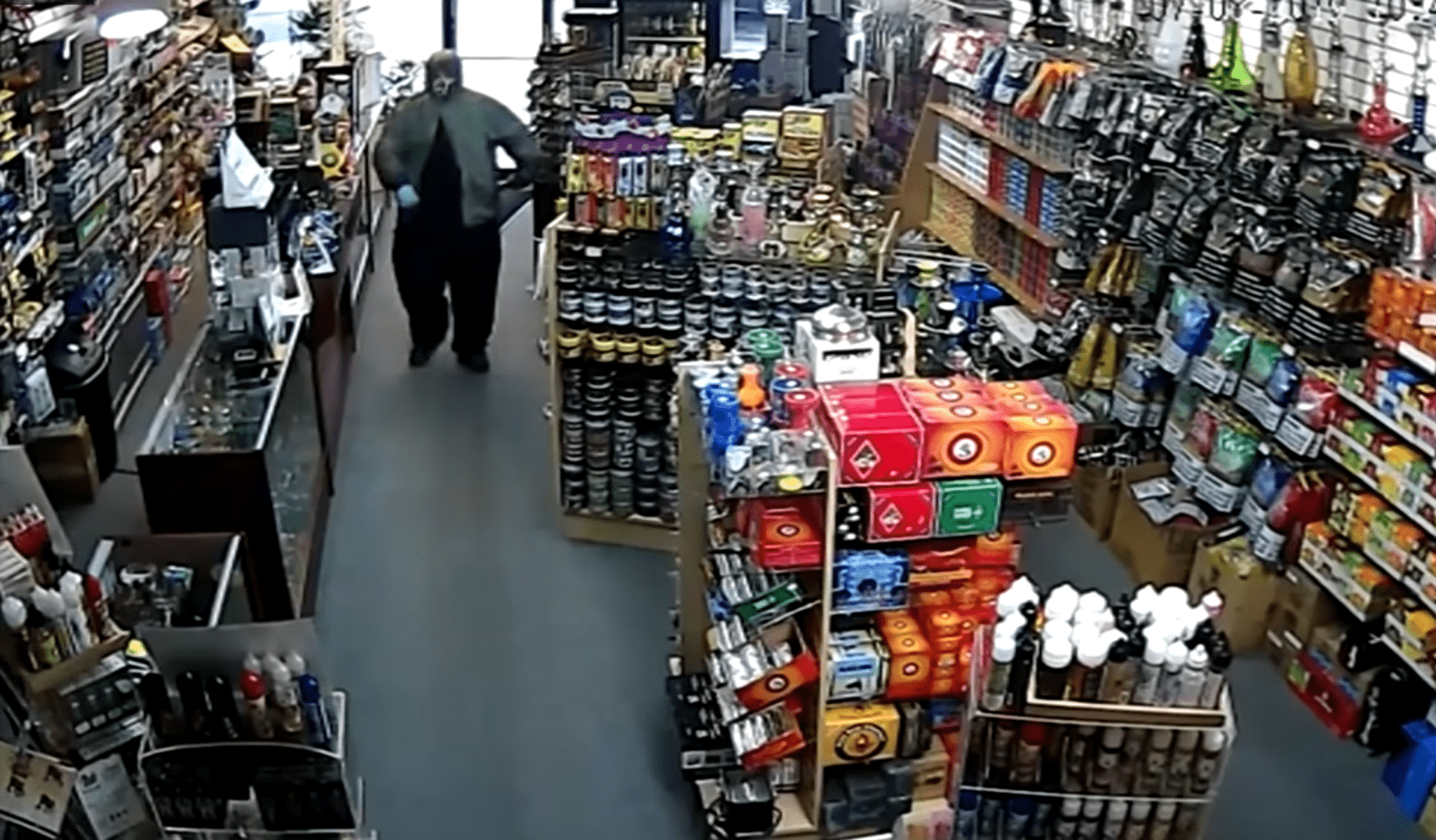 Disguised man with a gun walking into a store.┃Source: youtube.com/CBS 17
