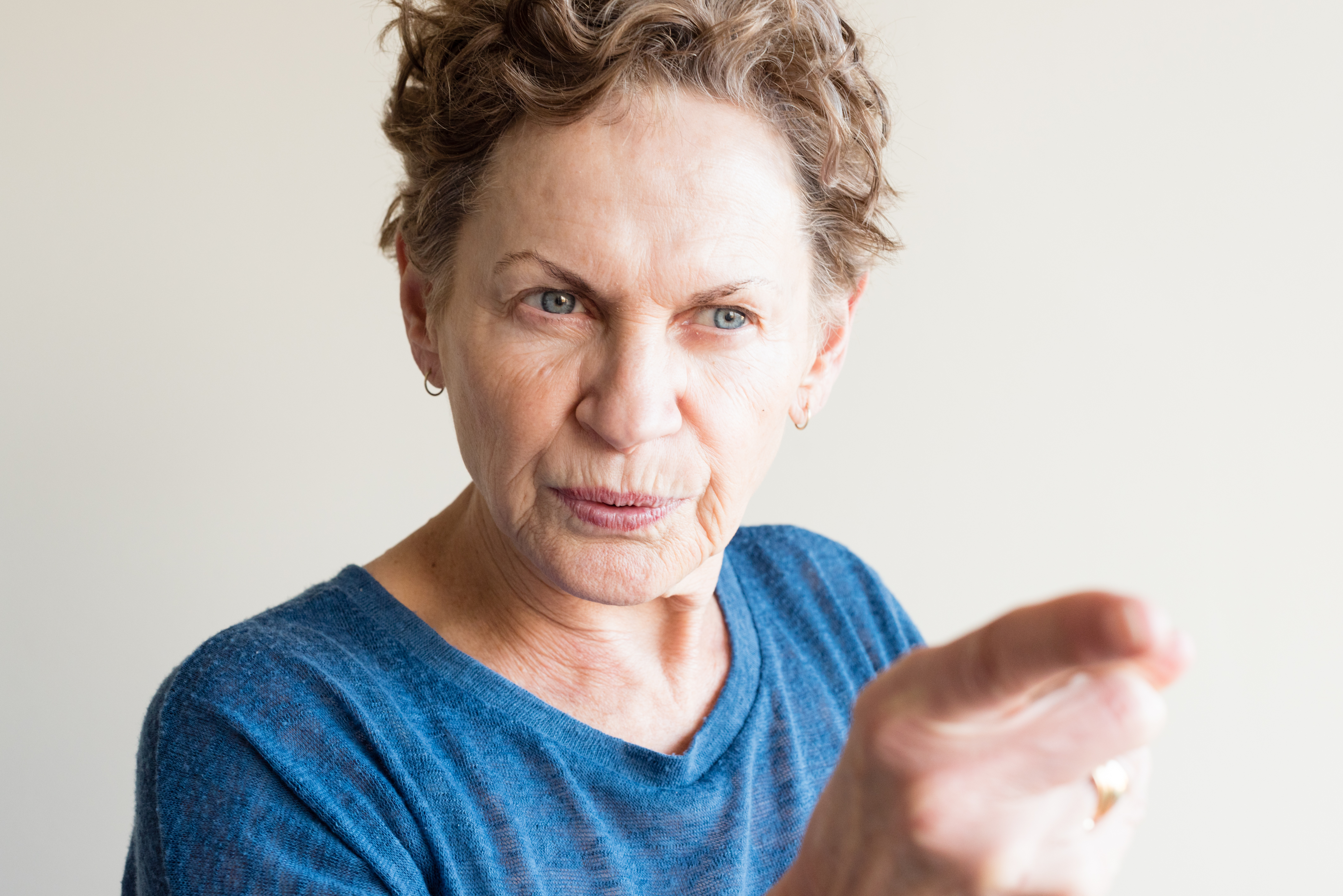 An elderly woman pointing her finger in anger | Source: Shutterstock