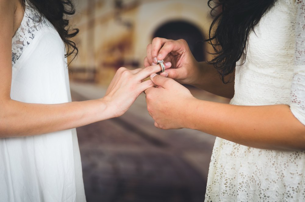 Mujer colocando el anillo de matrimonio a su novia en su boda. | Foto: Shutterstock