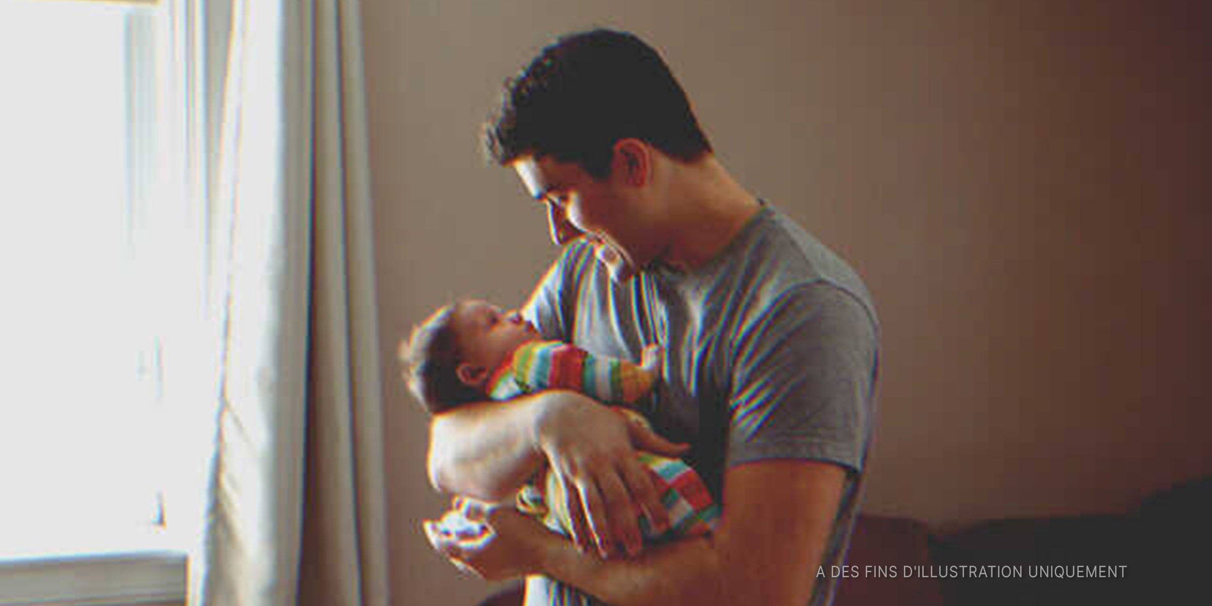 Un père tenant son enfant dans ses bras | Photo : Shutterstock