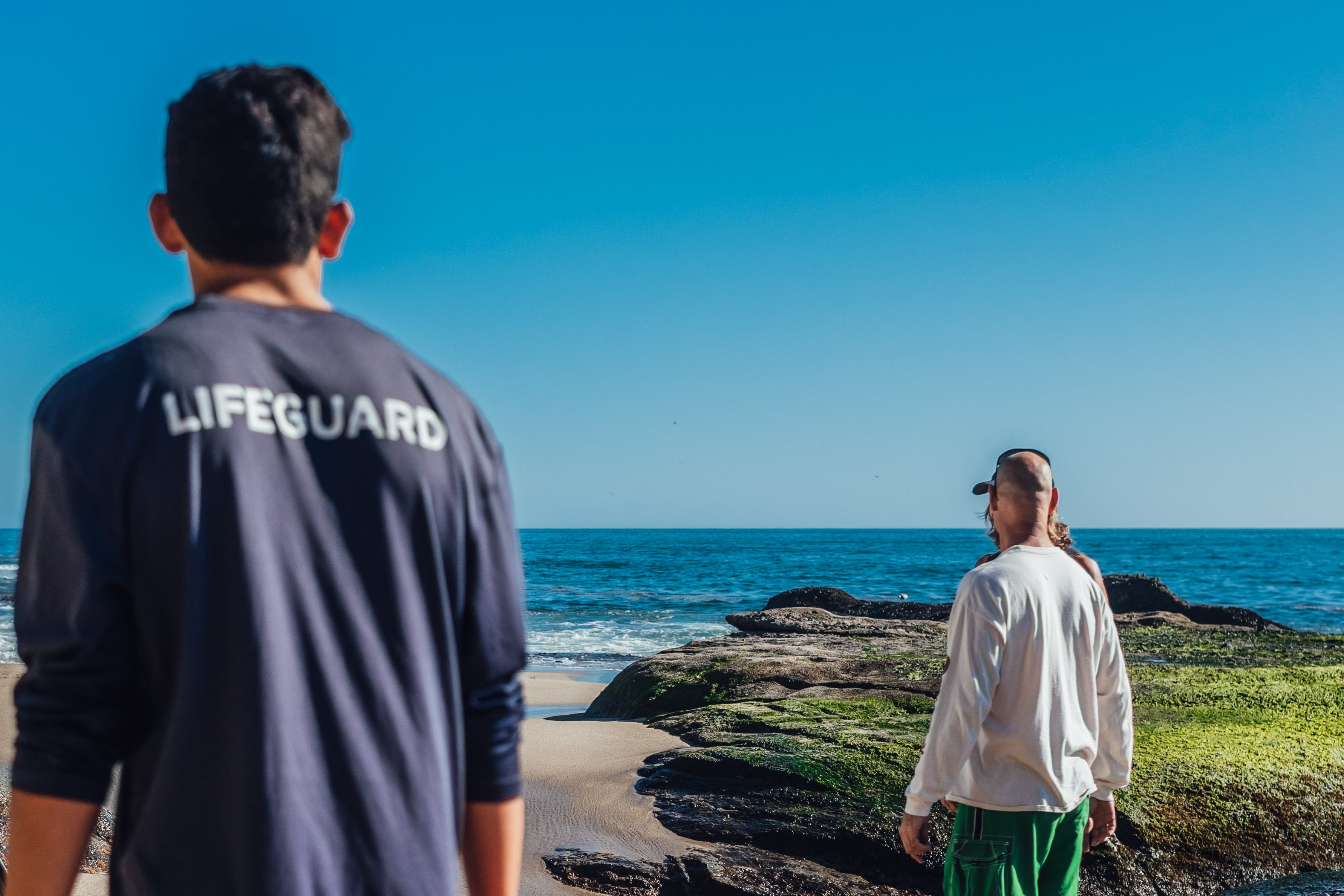 A lifeguard standing near the ocean. | Source: Pexels