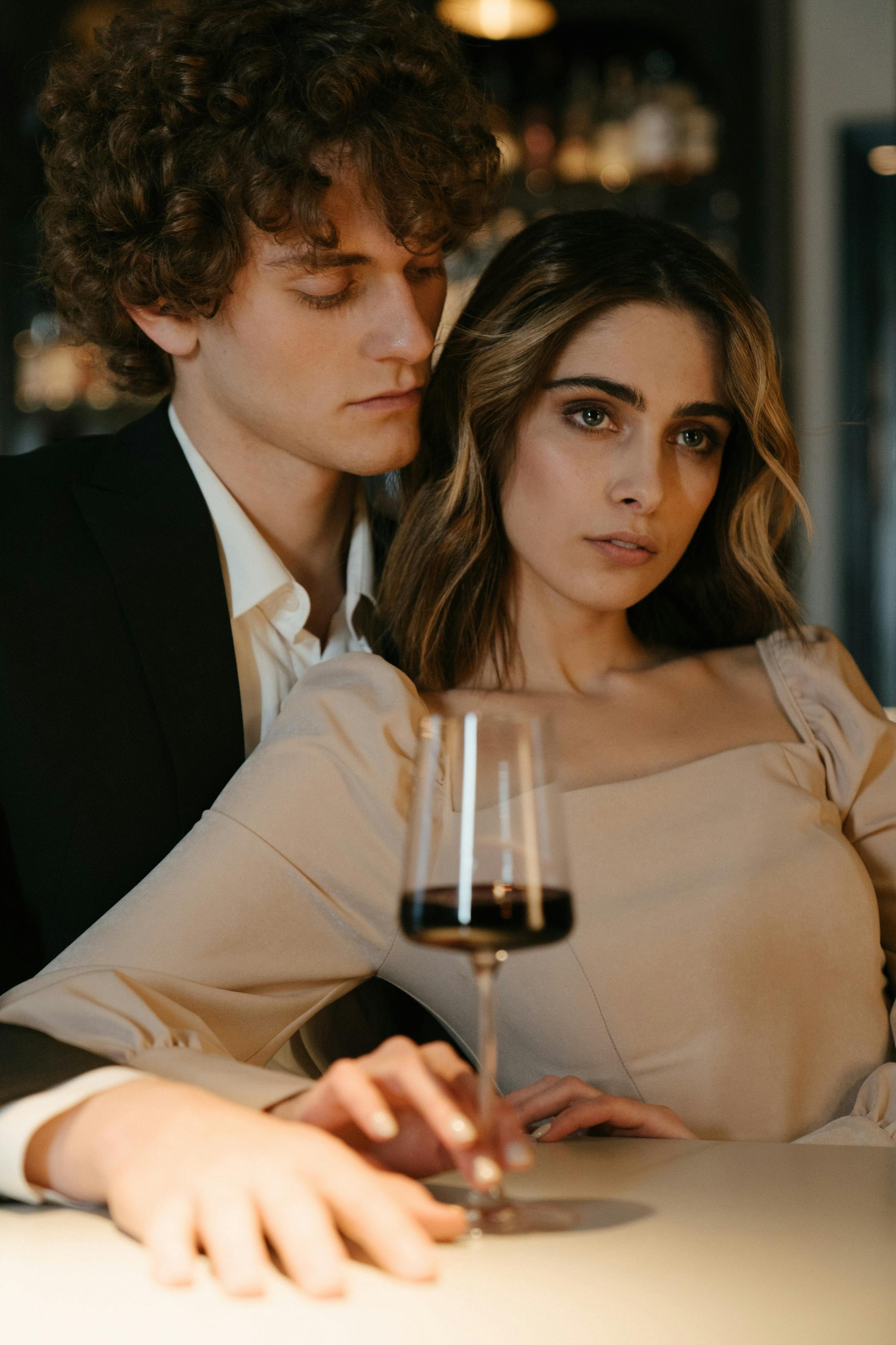 A woman leaning on her supportive man at a restaurant | Source: Pexels