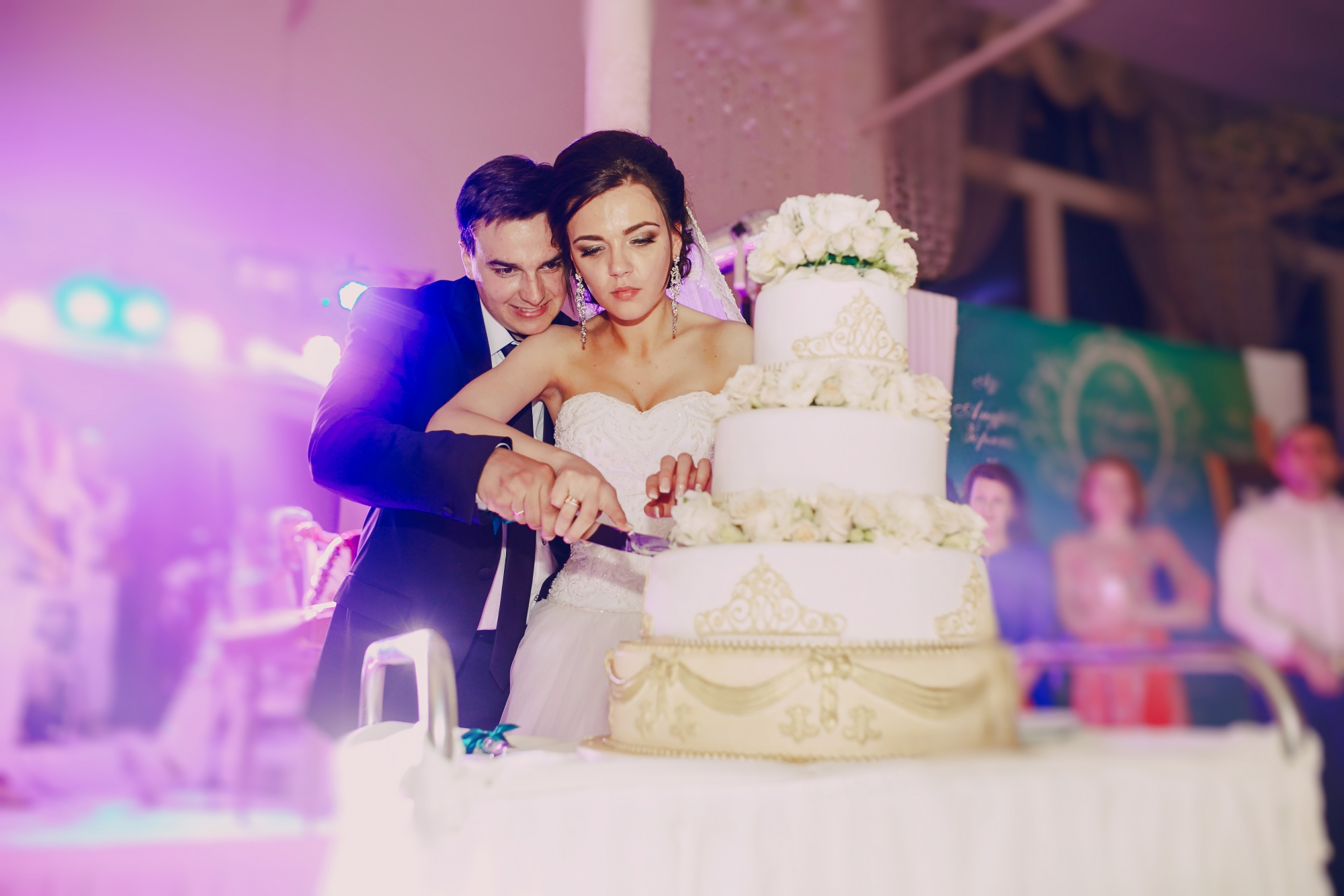 A newly-wed couple is seen cutting their wedding cake | Source: freepik